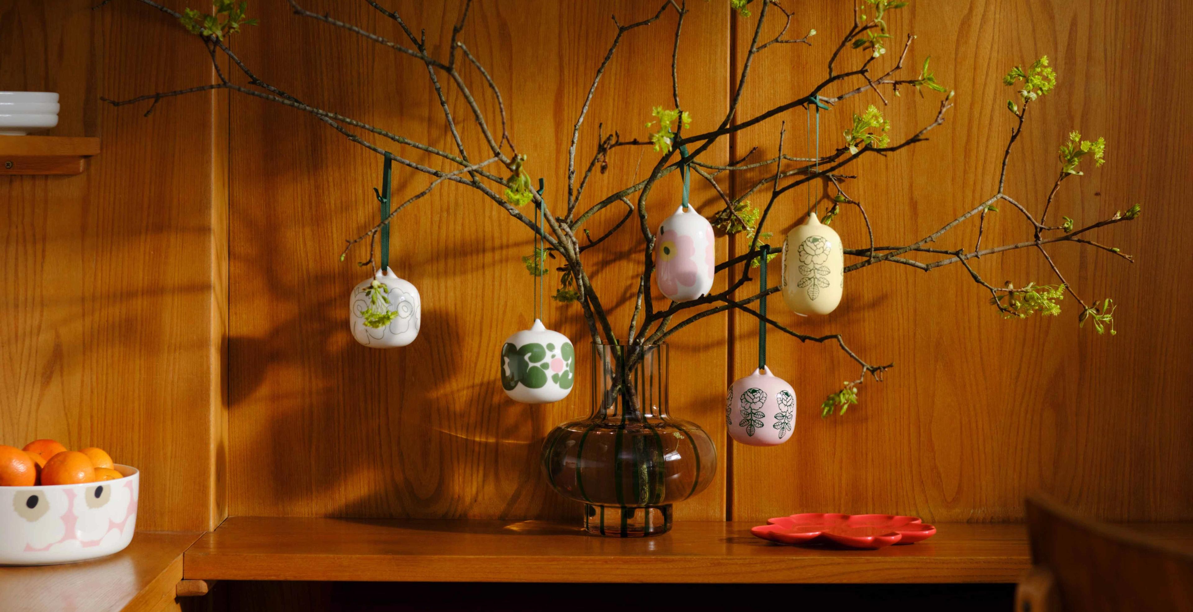 Vase with branches decorated with various ornaments in Marimekko's Unikko, Vihkiruusu, and Keidas prints