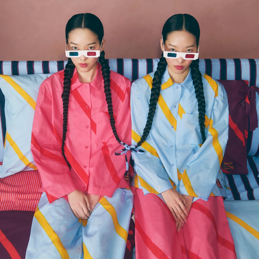 Twins sitting on a bed with matching pyjamas