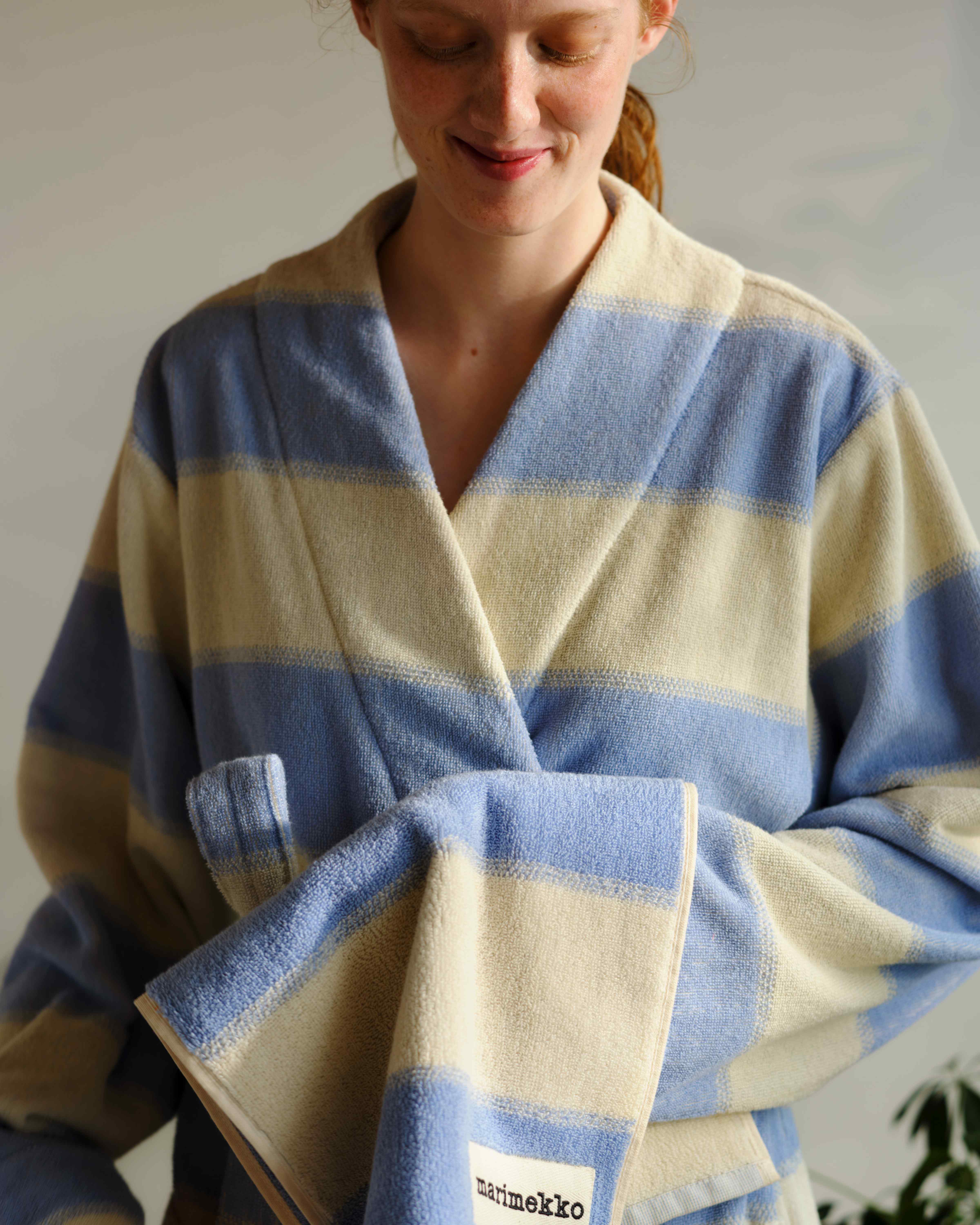 Model wearing a white and blue striped terry bath robe from Marimekko in Galleria print