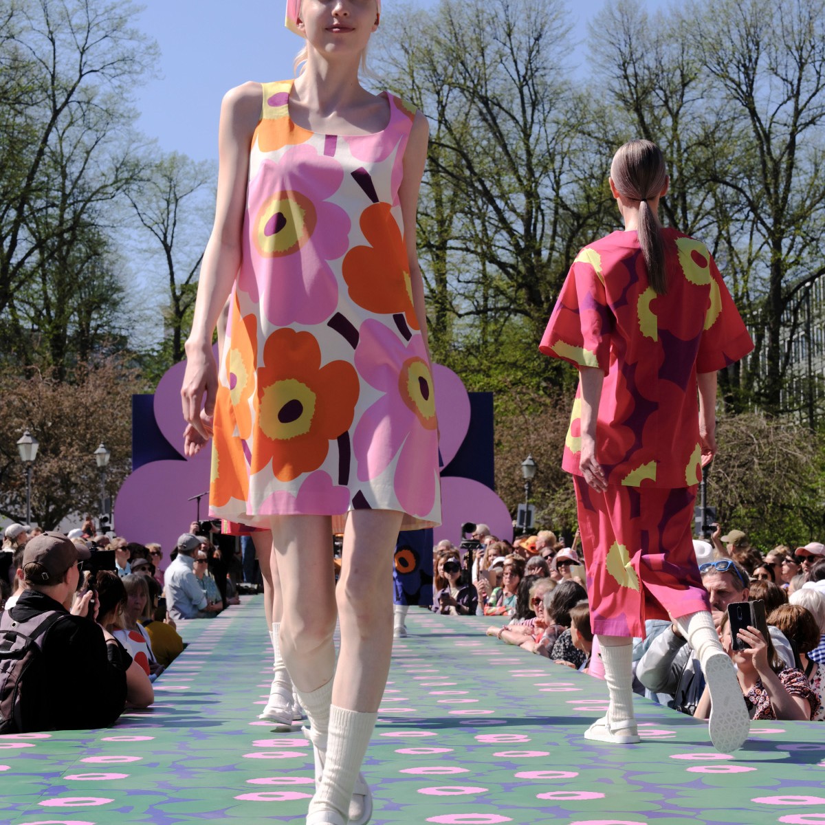 The model dressed in the pink-orange mini dress from the Unikko 60th anniversary collection.