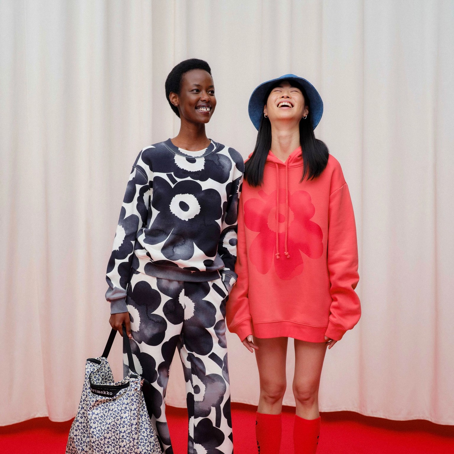 Models wearing sweatshirt and sweatpants in Unikko pattern and a red Runoja hoodie.