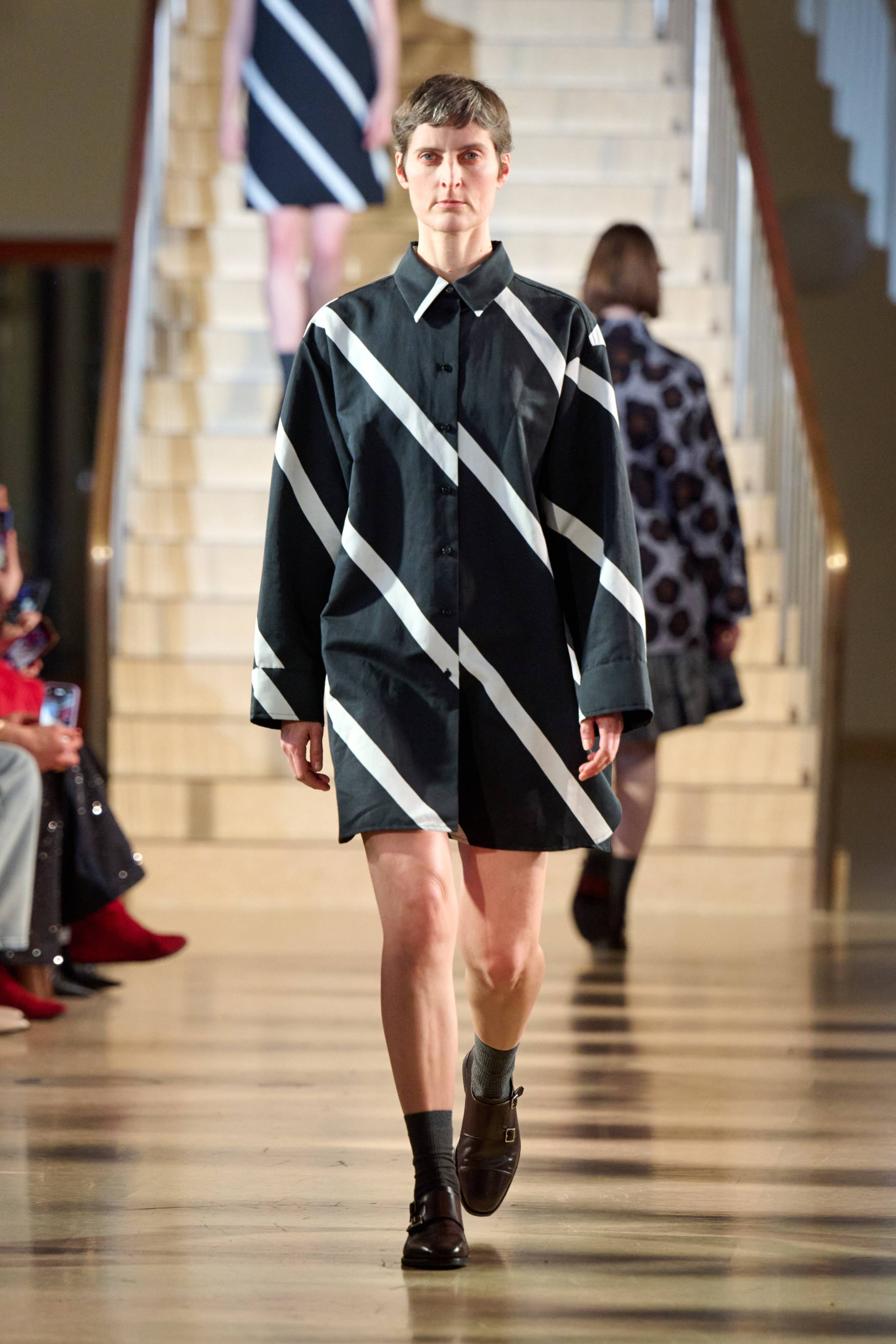 Model wearing black and white shirtdress.