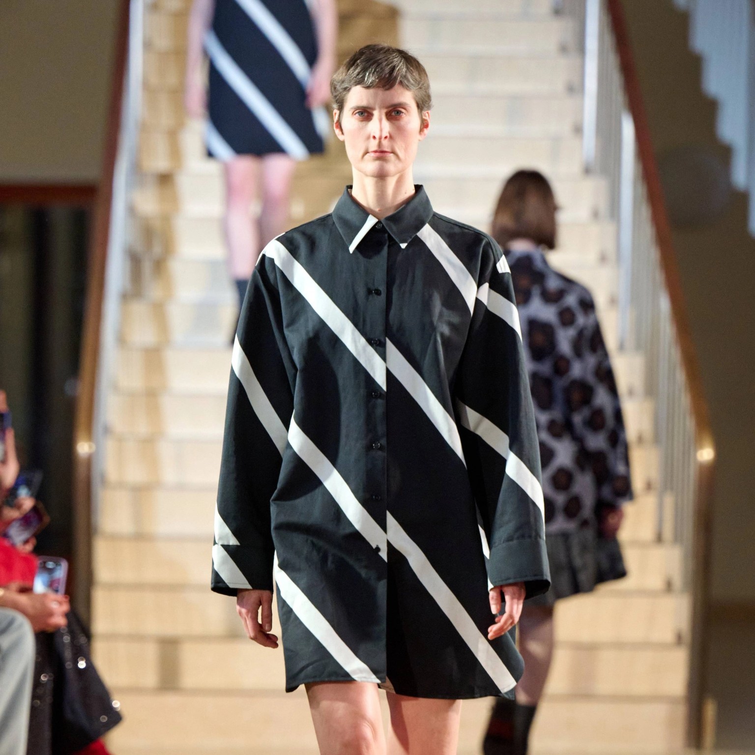 Model wearing black and white shirtdress.