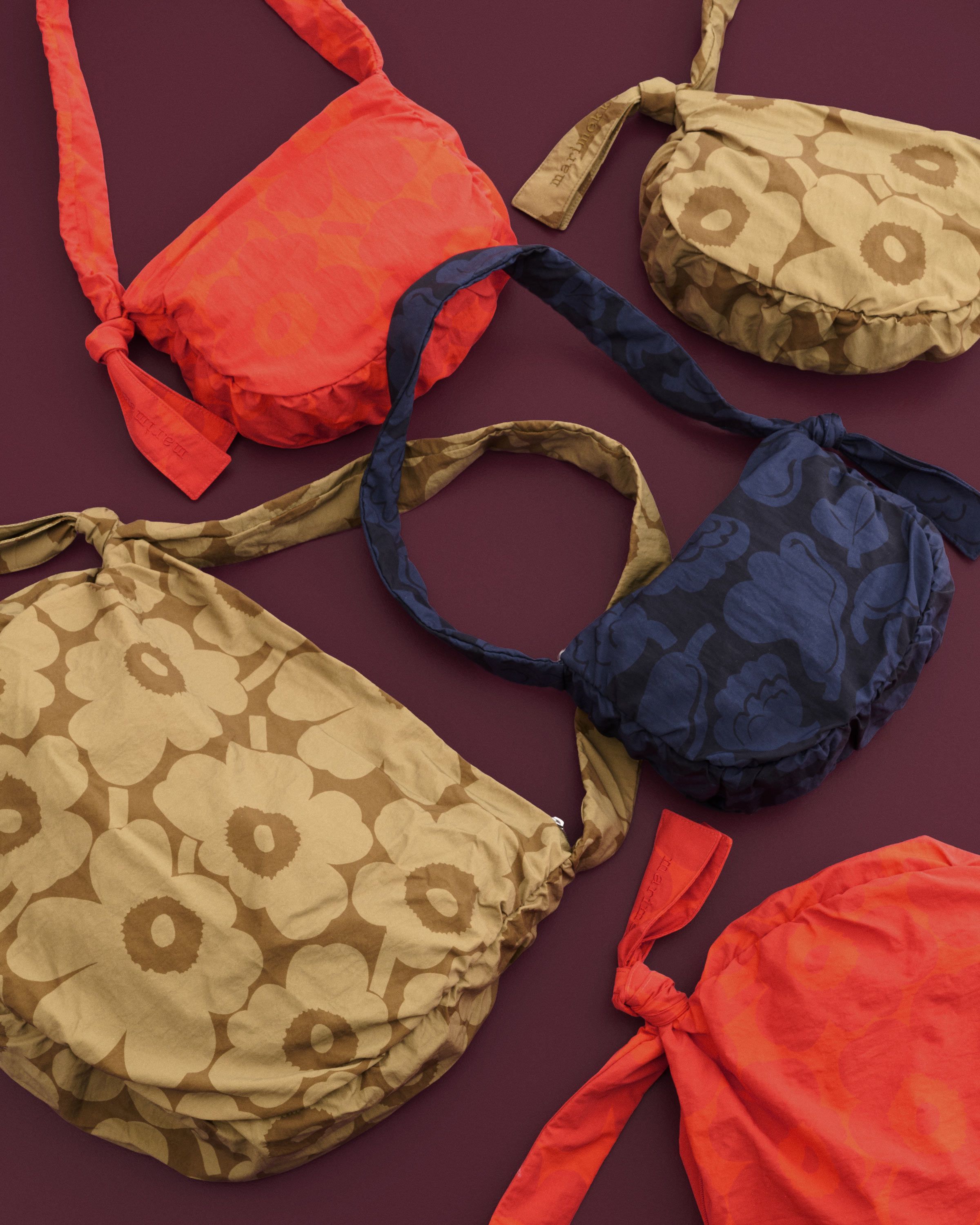 Orange, brown and dark blue Utu bags in Unikko and Kukasta kukkaan prints.