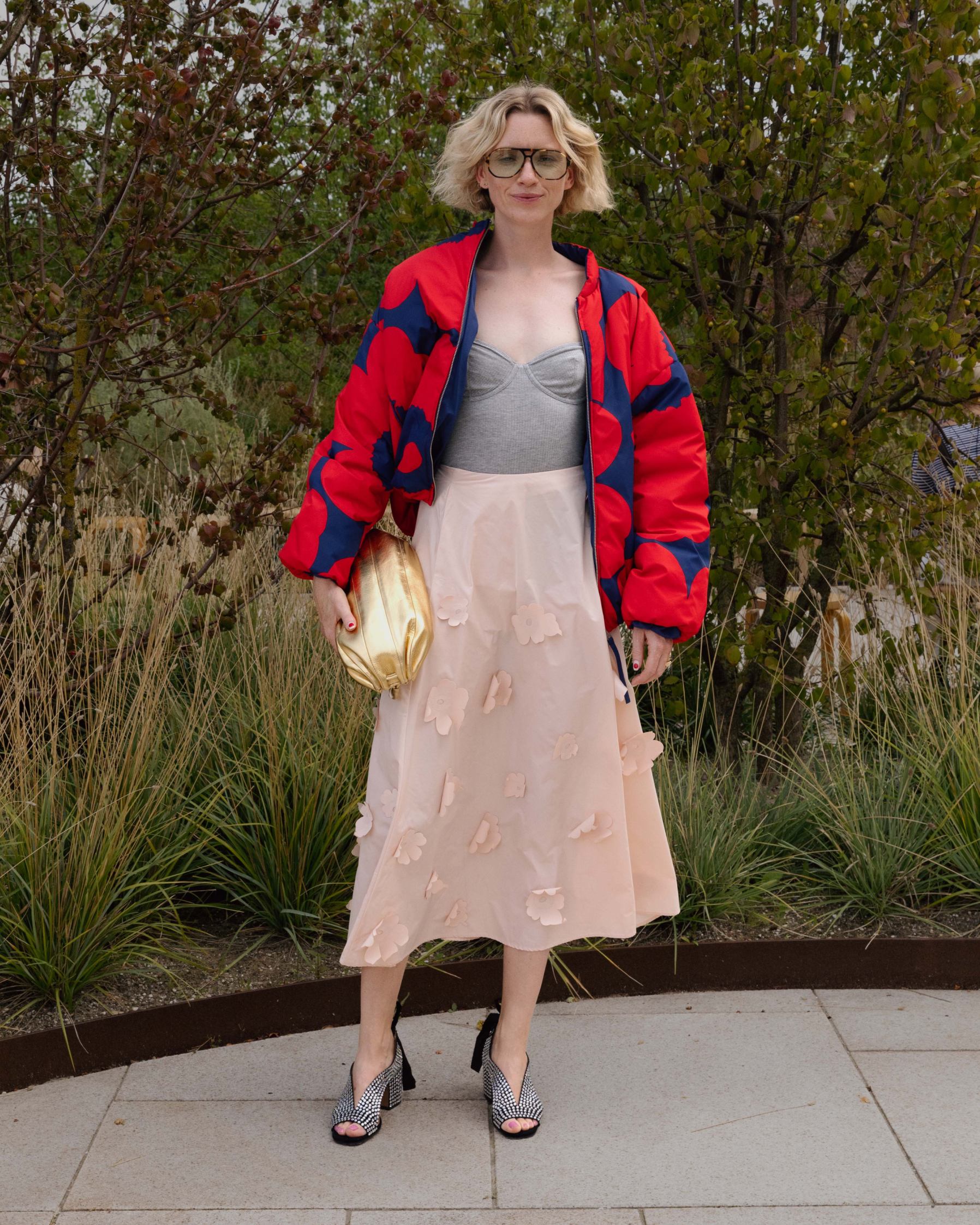 Pernille Rosenkilde wearing 3D Unikko skirt, red-blue Unikko jacket and golden Karla bag.