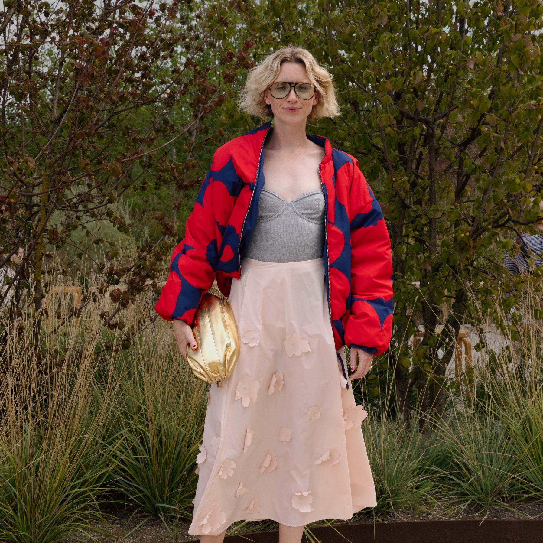 Pernille Rosenkilde wearing 3D Unikko skirt, red-blue Unikko jacket and golden Karla bag.