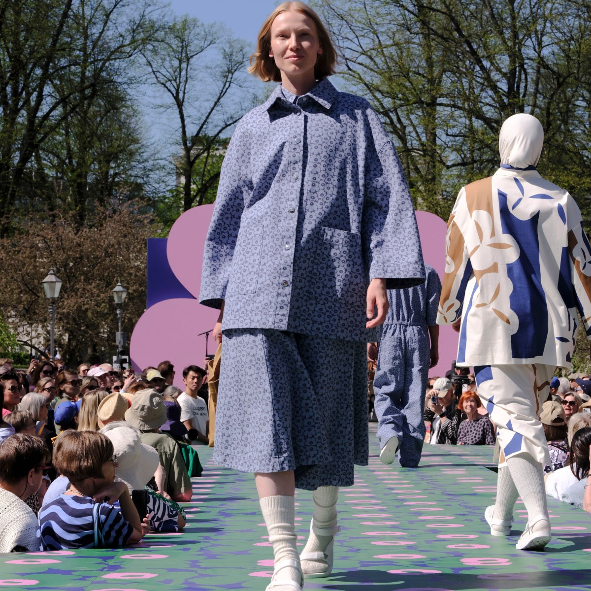 Model is dressed in a blue shirt jacket and skirt with Unikko patterns.