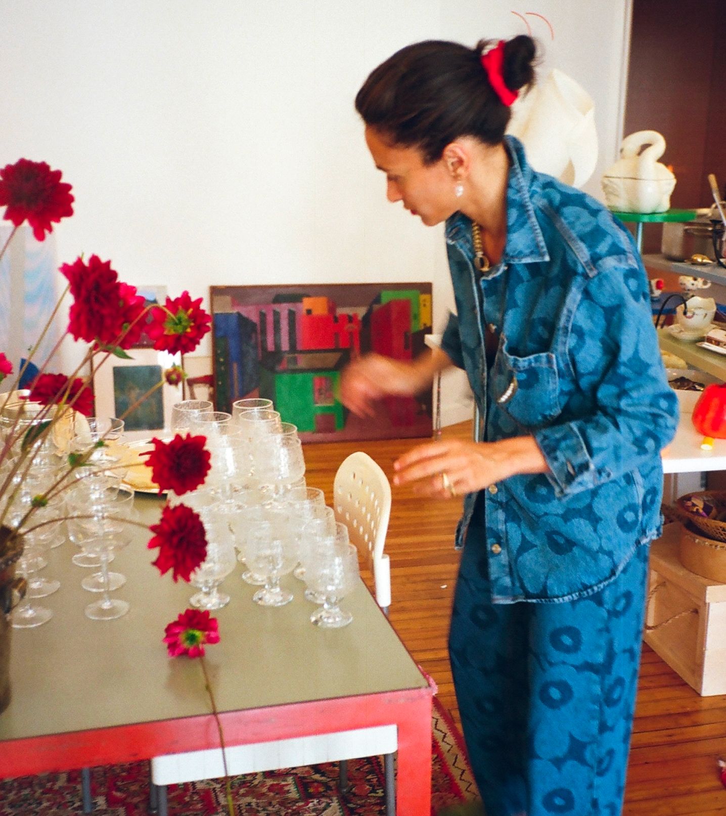 Laila Gohar setting up dinner table and wearing Maridenim jeans and shirt