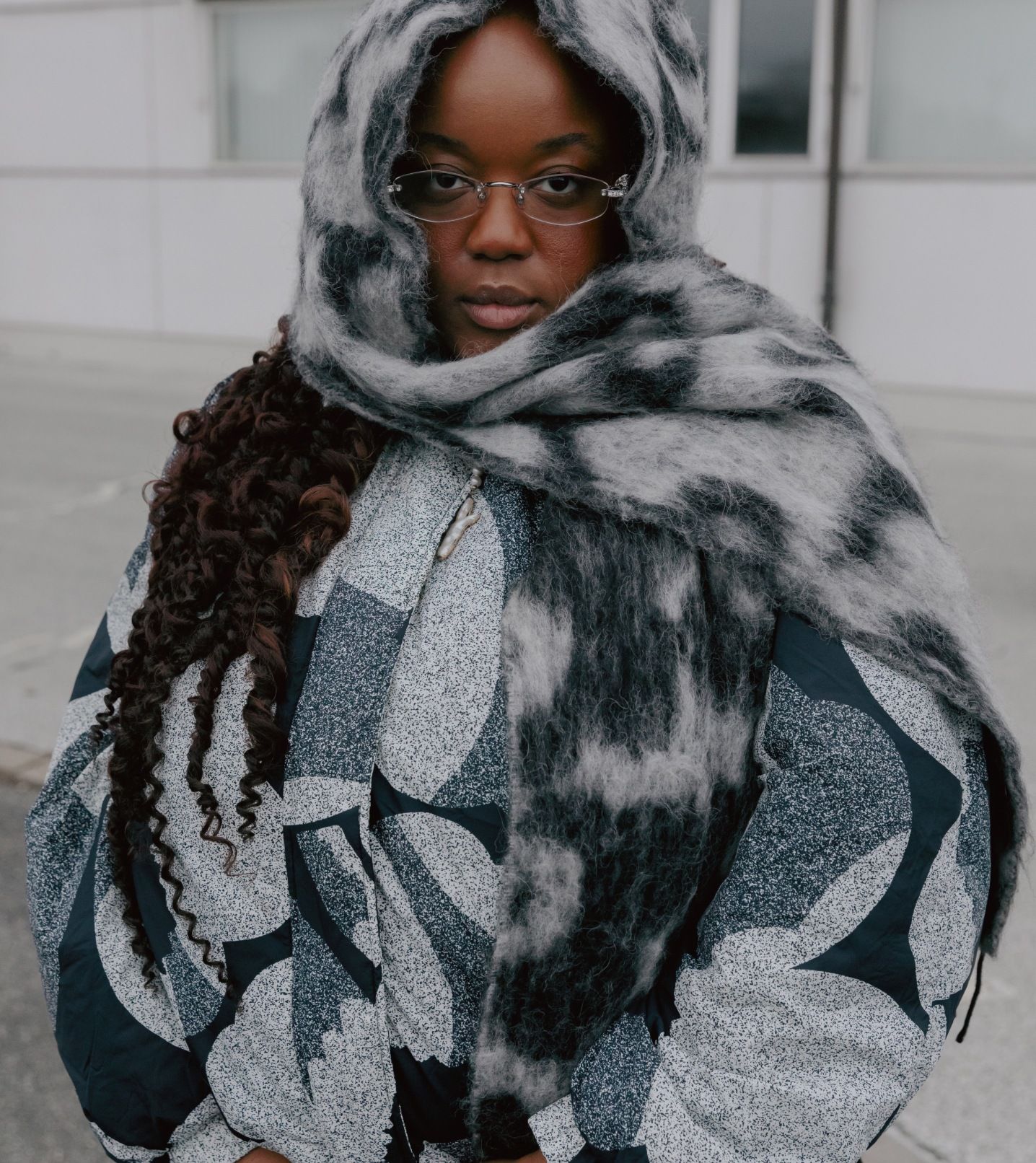 Ashlyn Delaney wrapped in a black and white quilted jacket and scarf with a Unikko pattern.