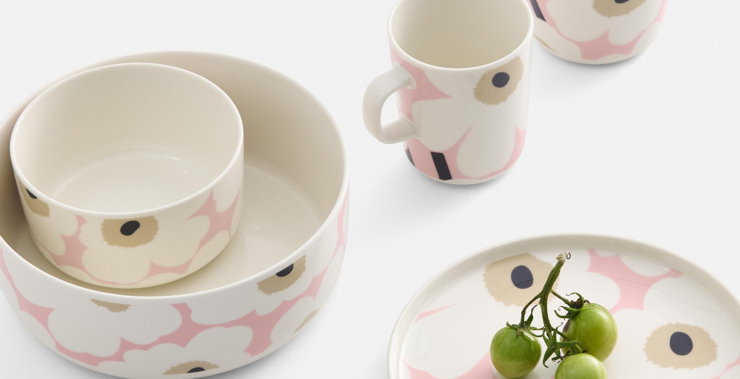 Mugs, bowls and plates with a pink and white Unikko pattern. 