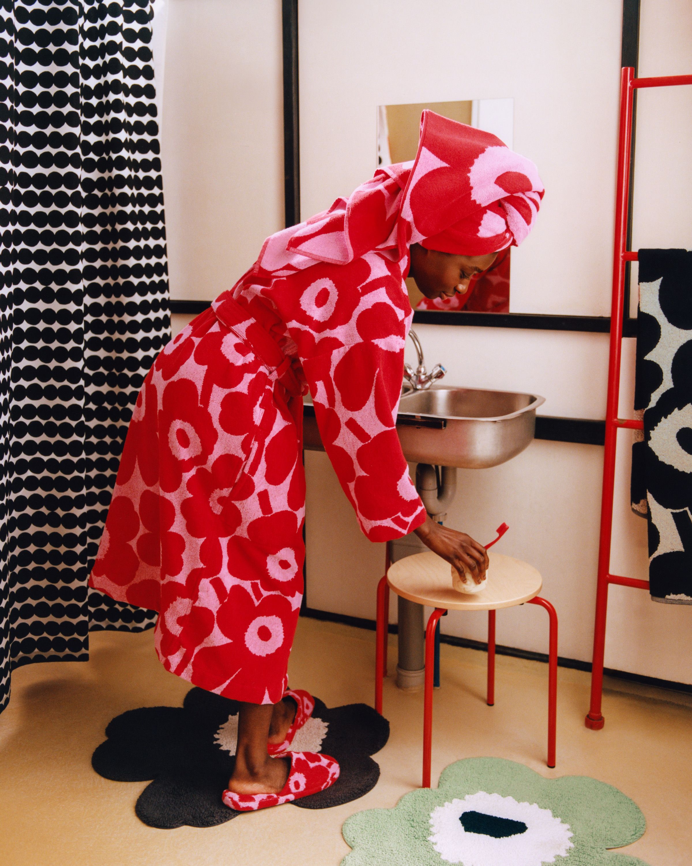Person in bathroom wearing Unikko bathrobe, towel on head, and slippers. 