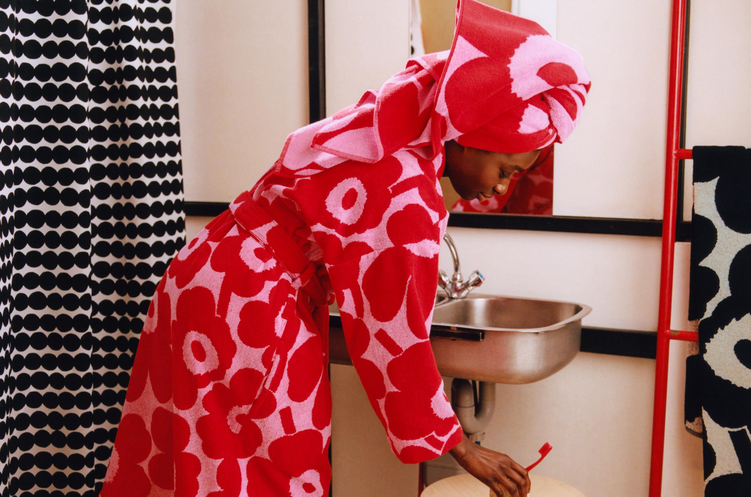 Person in bathroom wearing Unikko bathrobe, towel on head, and slippers.