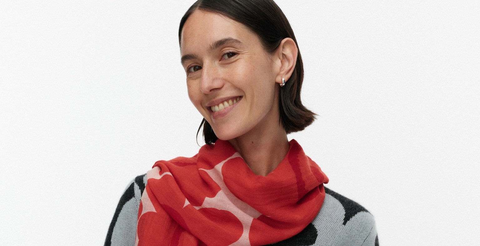 Model wearing a red and pink Fiore scarf in Unikko pattern.