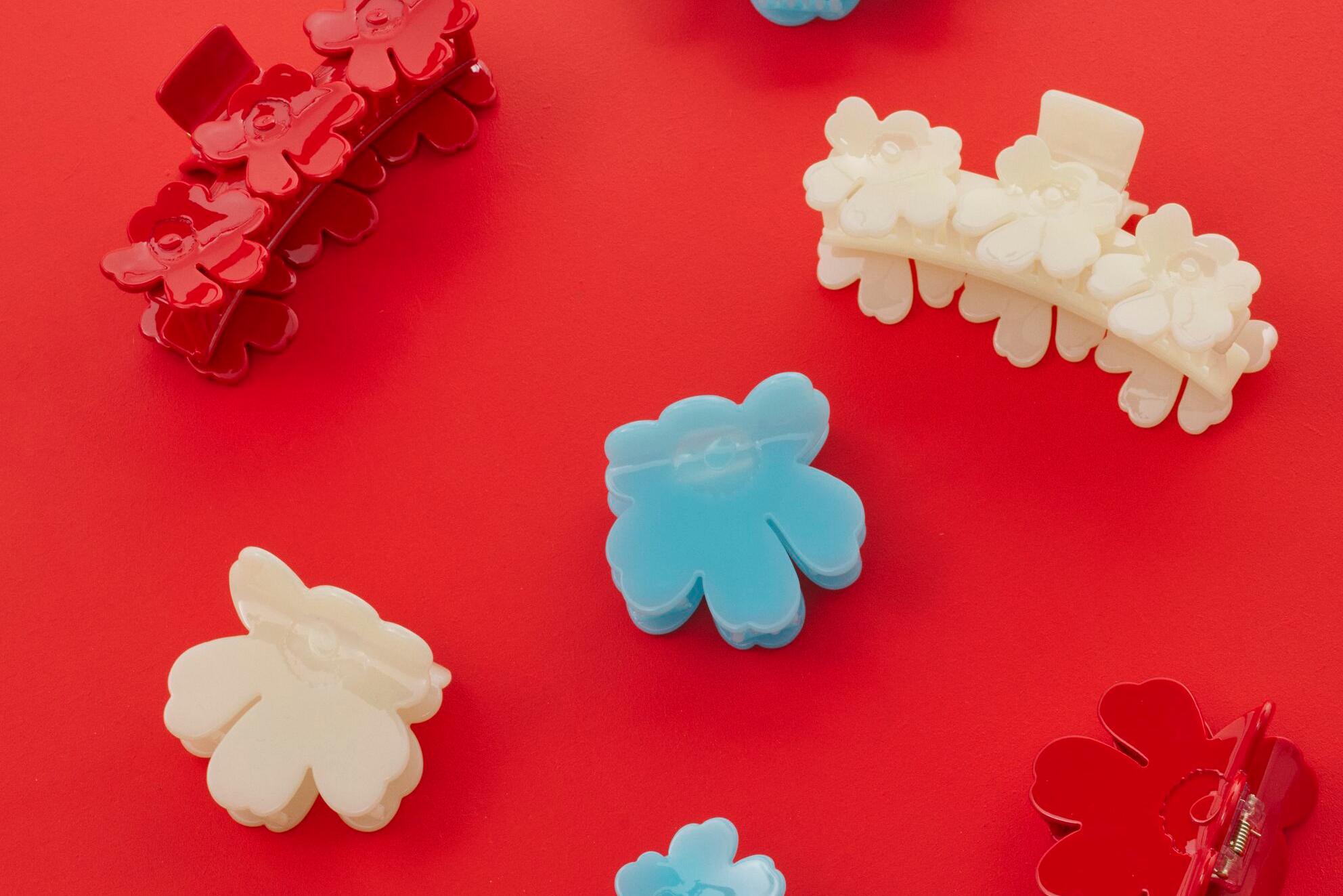 Pinces à cheveux Unikko colorées sur un fond rouge.