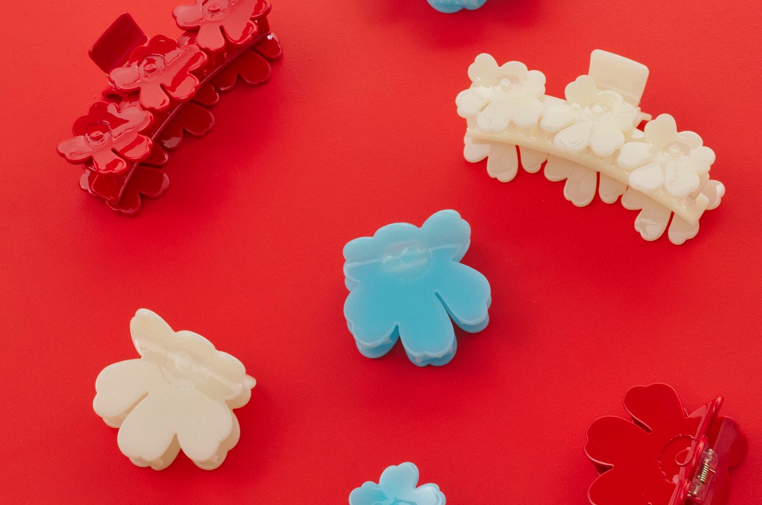 Colorful Unikko hair clips on a red background.