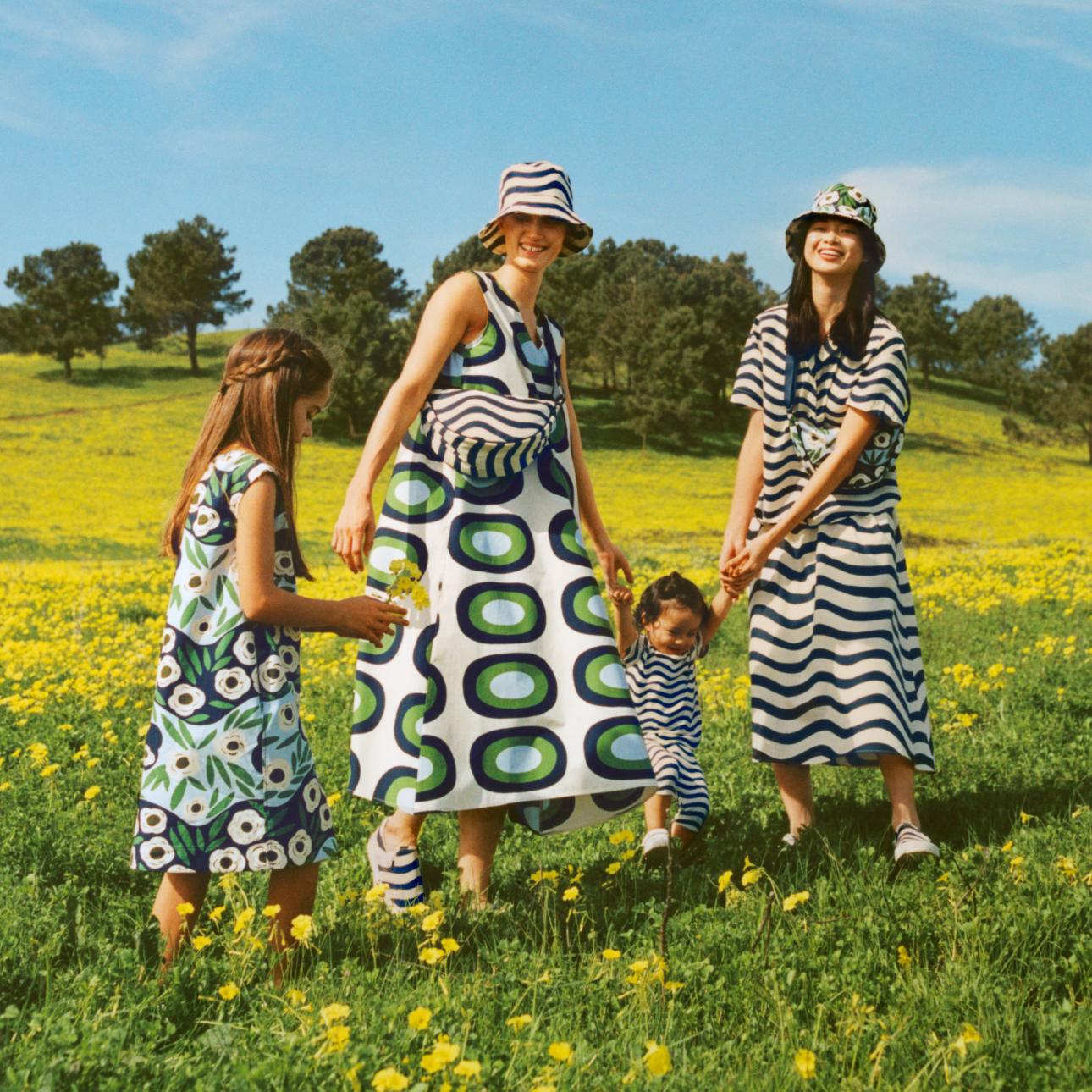 Kinder und Frau in einem Blumenfeld, die Kleidung aus der Zusammenarbeit von Uniqlo und Marimekko tragen