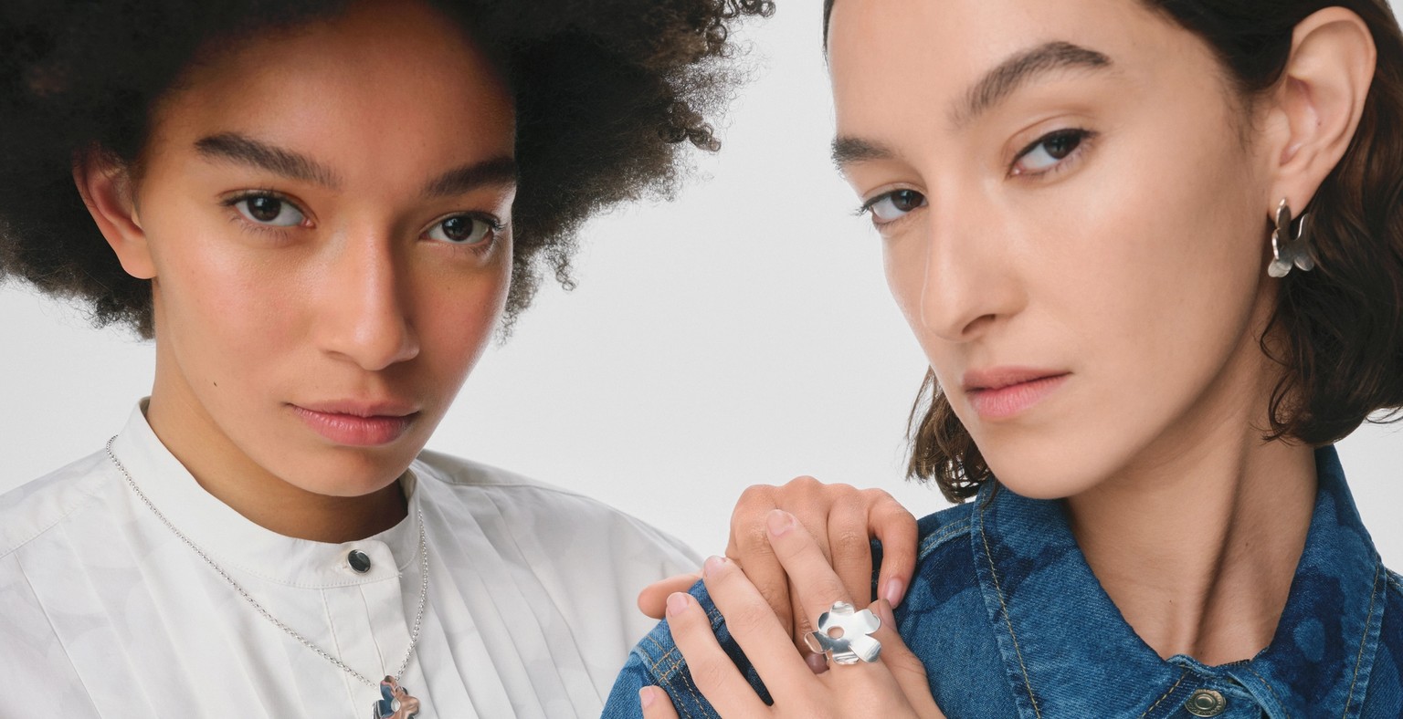 Models wearing Kalevala and Marimekko collaboration silver necklace, ring and earrings in Unikko pattern