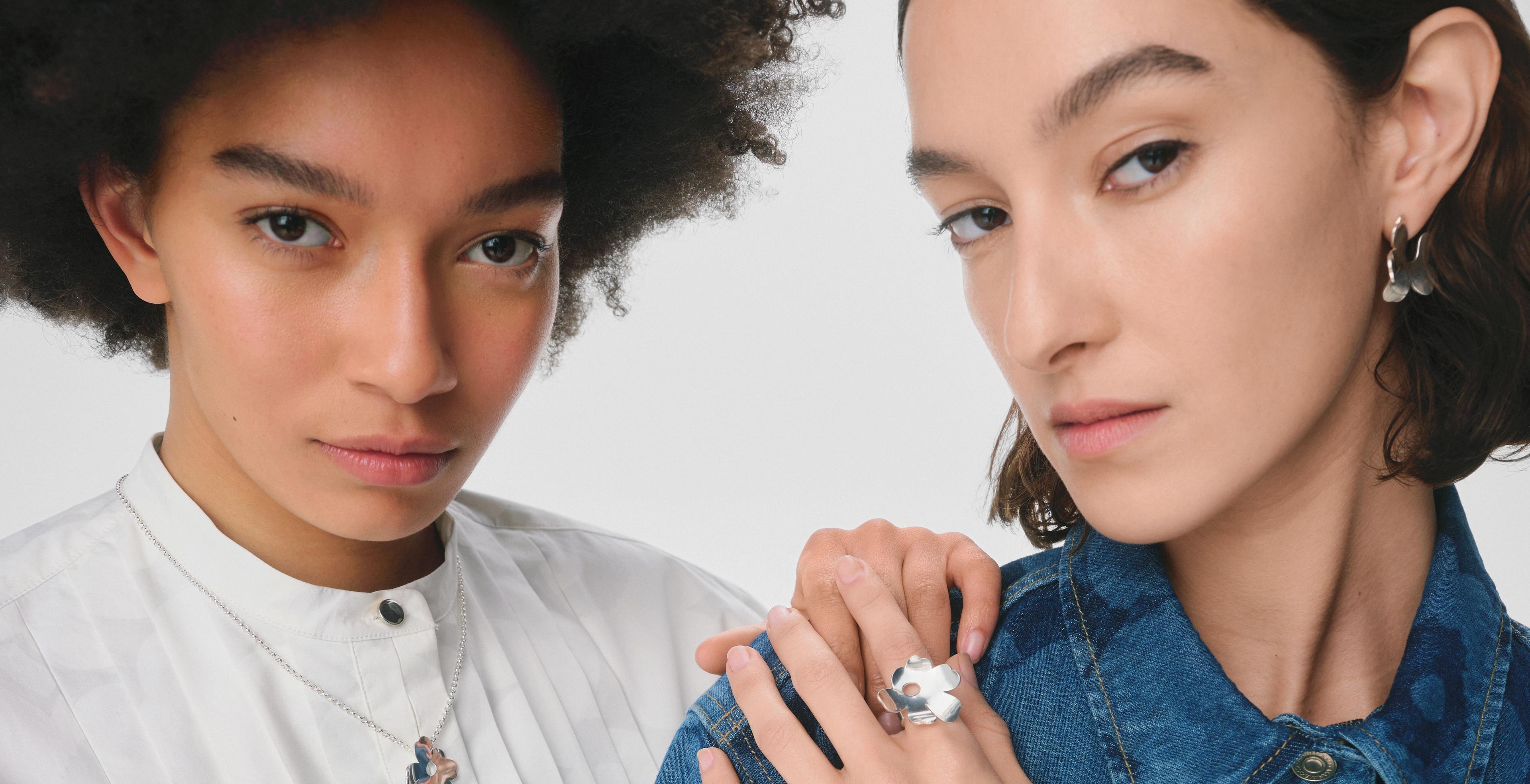 Models wearing Kalevala and Marimekko collaboration silver necklace, ring and earrings in Unikko pattern