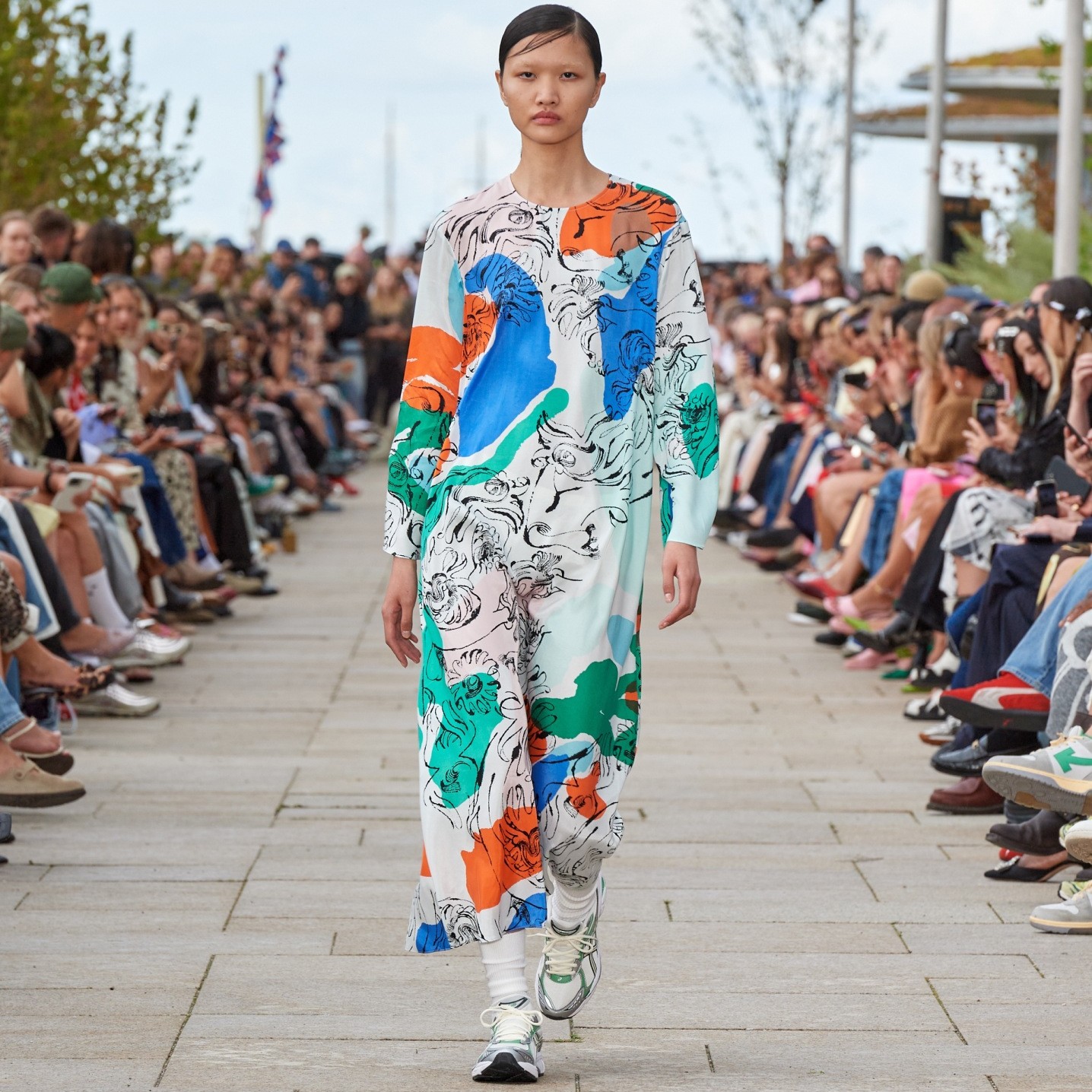 Model walking on the catwalk of the fashion show dressed in Fluidi Blombom dress.