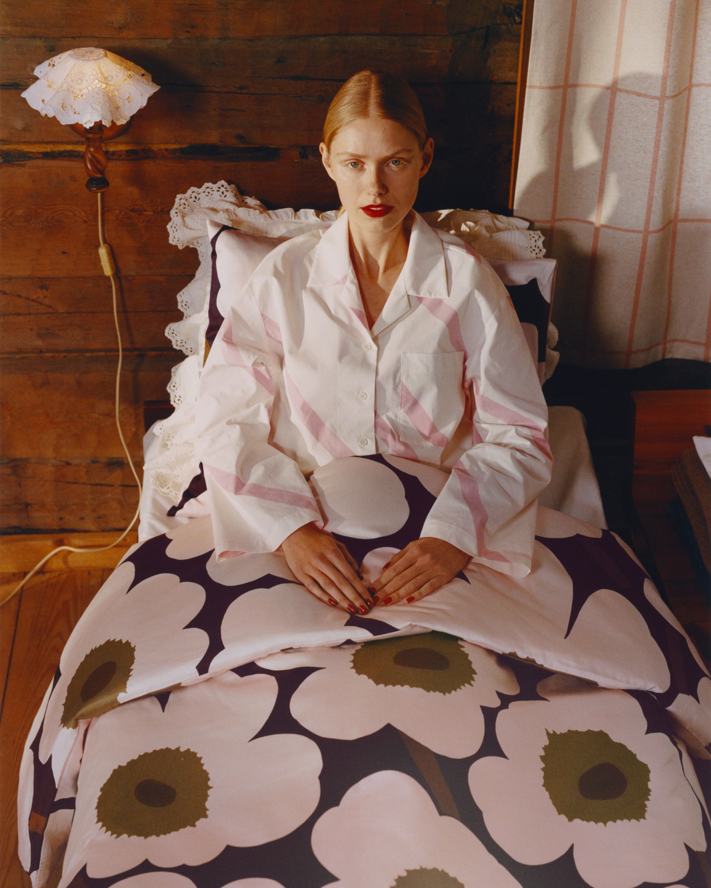 Model in bed with Unikko sheets and Basso pyjama