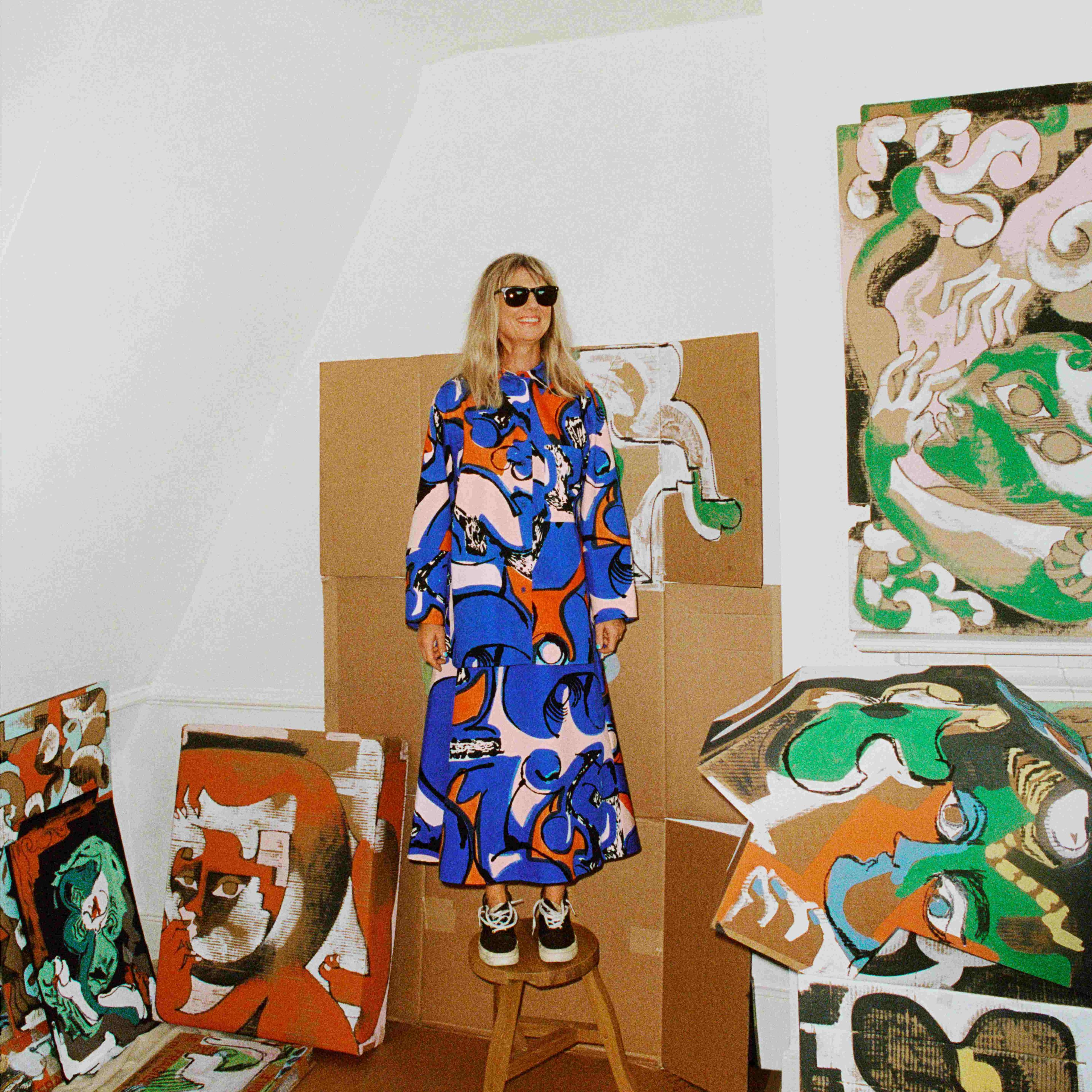 Petra Börner standing on a stool wearing a shirt and skirt from the Petra Börner and Marimekko collaboration