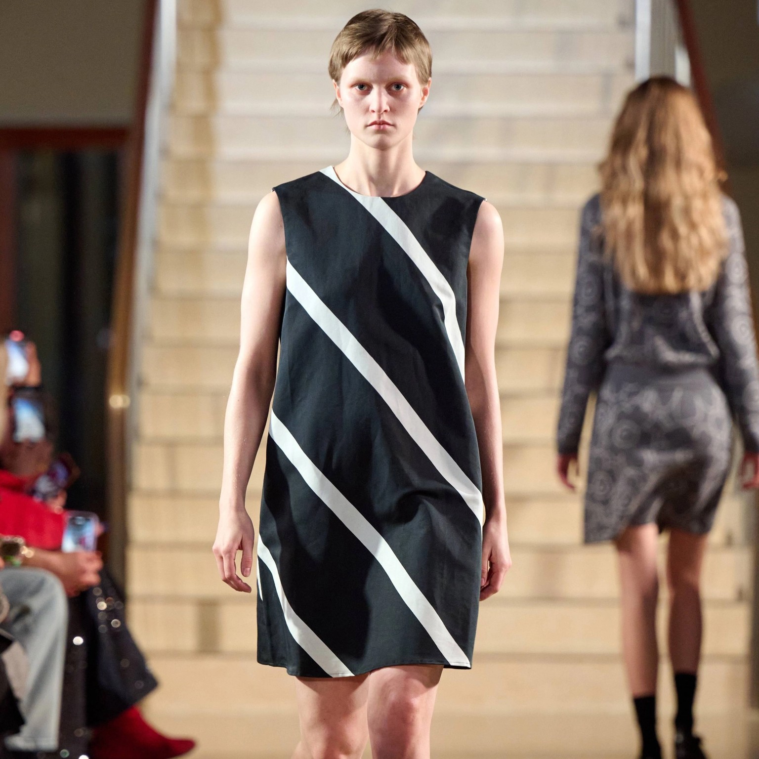 Model wearing a black and white striped dress.