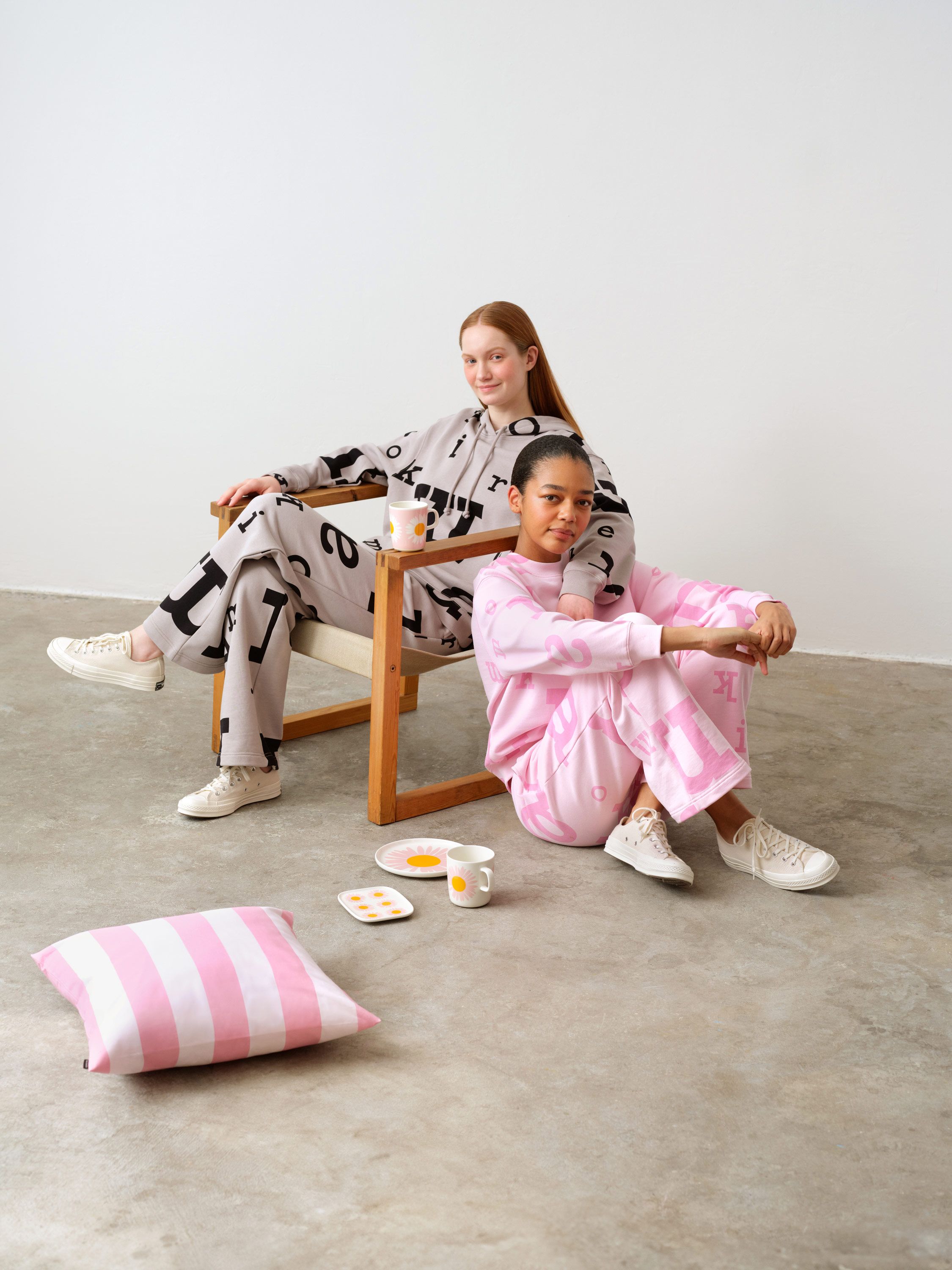 Mallit istuvat tuolilla ja lattialla, päällän Marimerkki collegesetit.