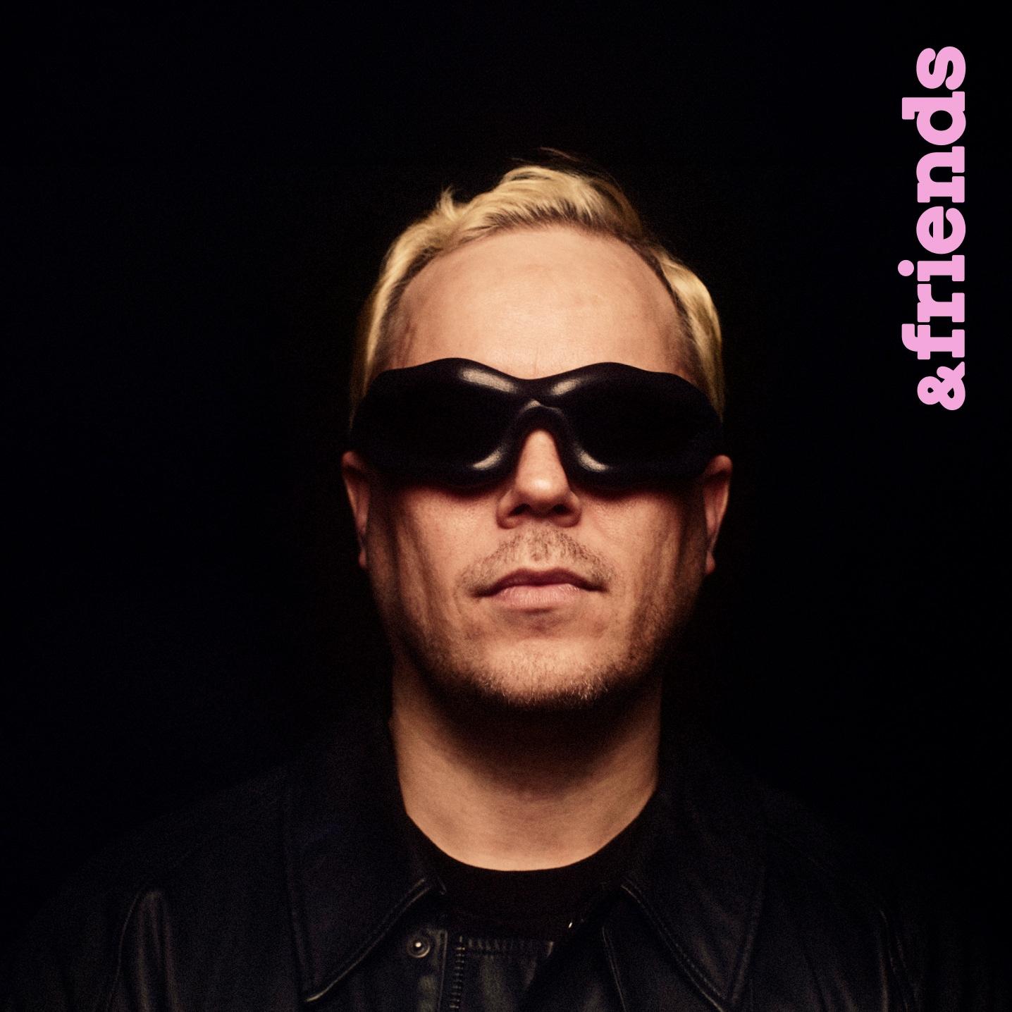 A portrait of a man wearing sunglasses (Karri Koira) with a vertical text ''Marimekko'' in the top right corner.