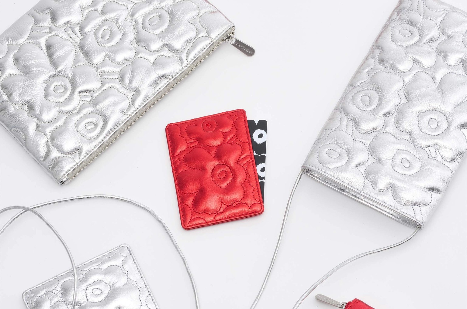 Shiny red and silver Unikko-quilted leather accessories and small bags.