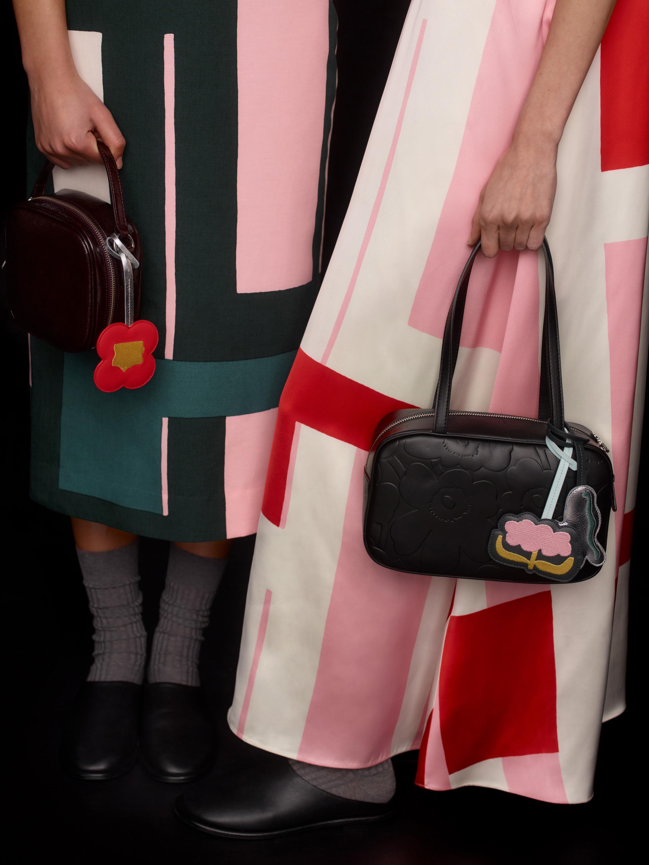 Two models carrying black Marimekko Gratha leather bags.