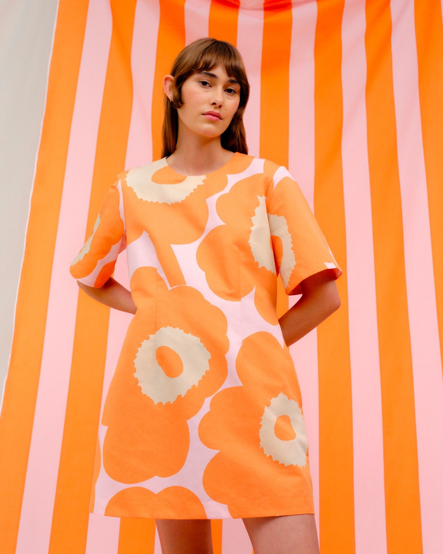 Model wearing an orange Unikko minidress.