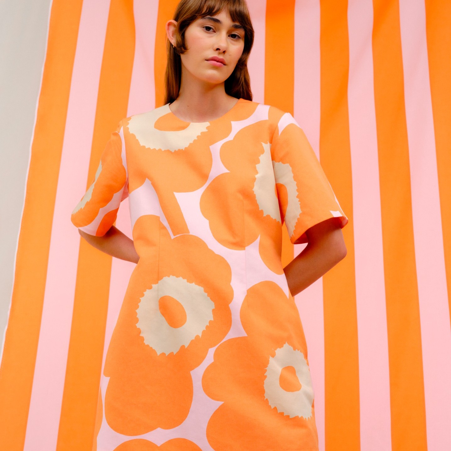 Modell, das ein oranges Unikko-Minikleid trägt.