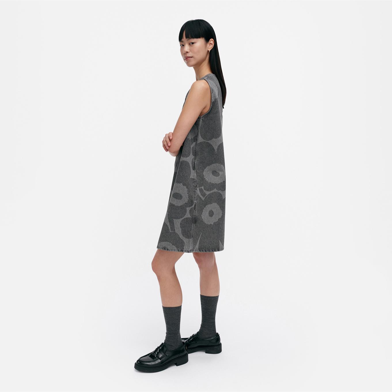 Model wearing Maridenim Marimini dress in grey Unikko pattern.