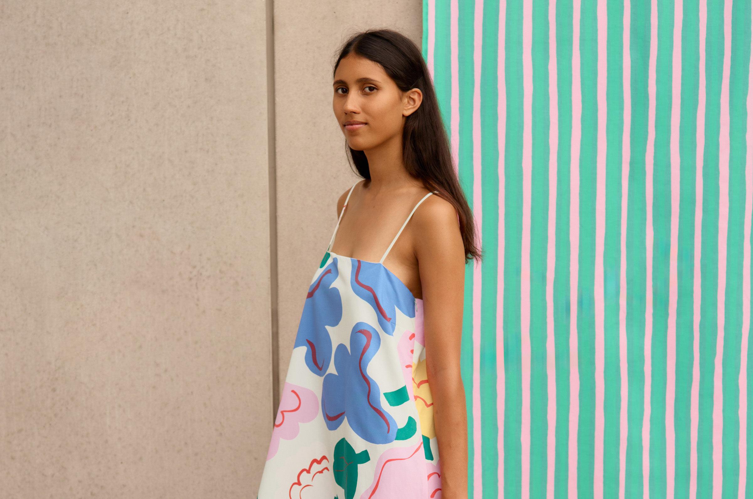 Model wearing a dress with Kukasta Kukkaan pattern and a knitted Unikko bag.