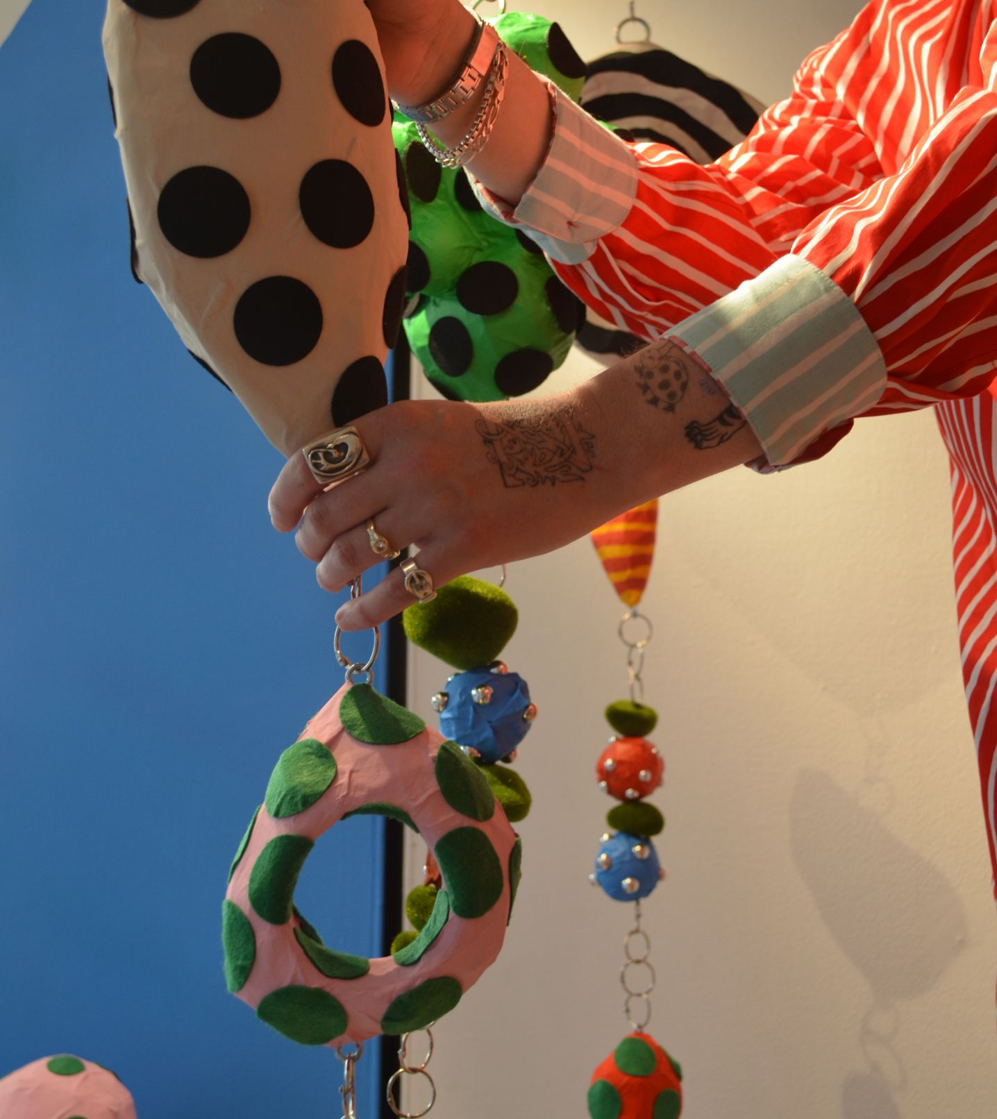 Zander Schlacter holding his artwork, designed for the window of a New York store.