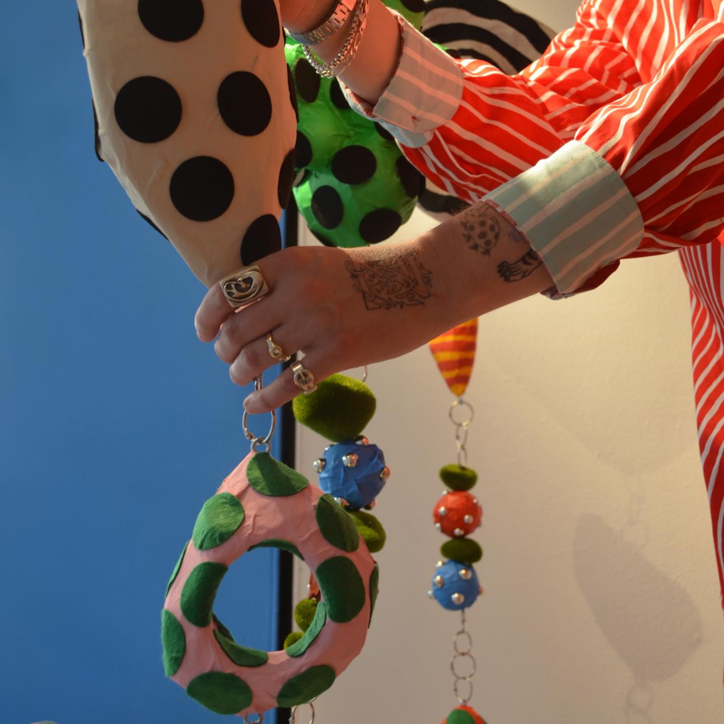 Zander Schlacter holding his artwork, designed for the window of a New York store.