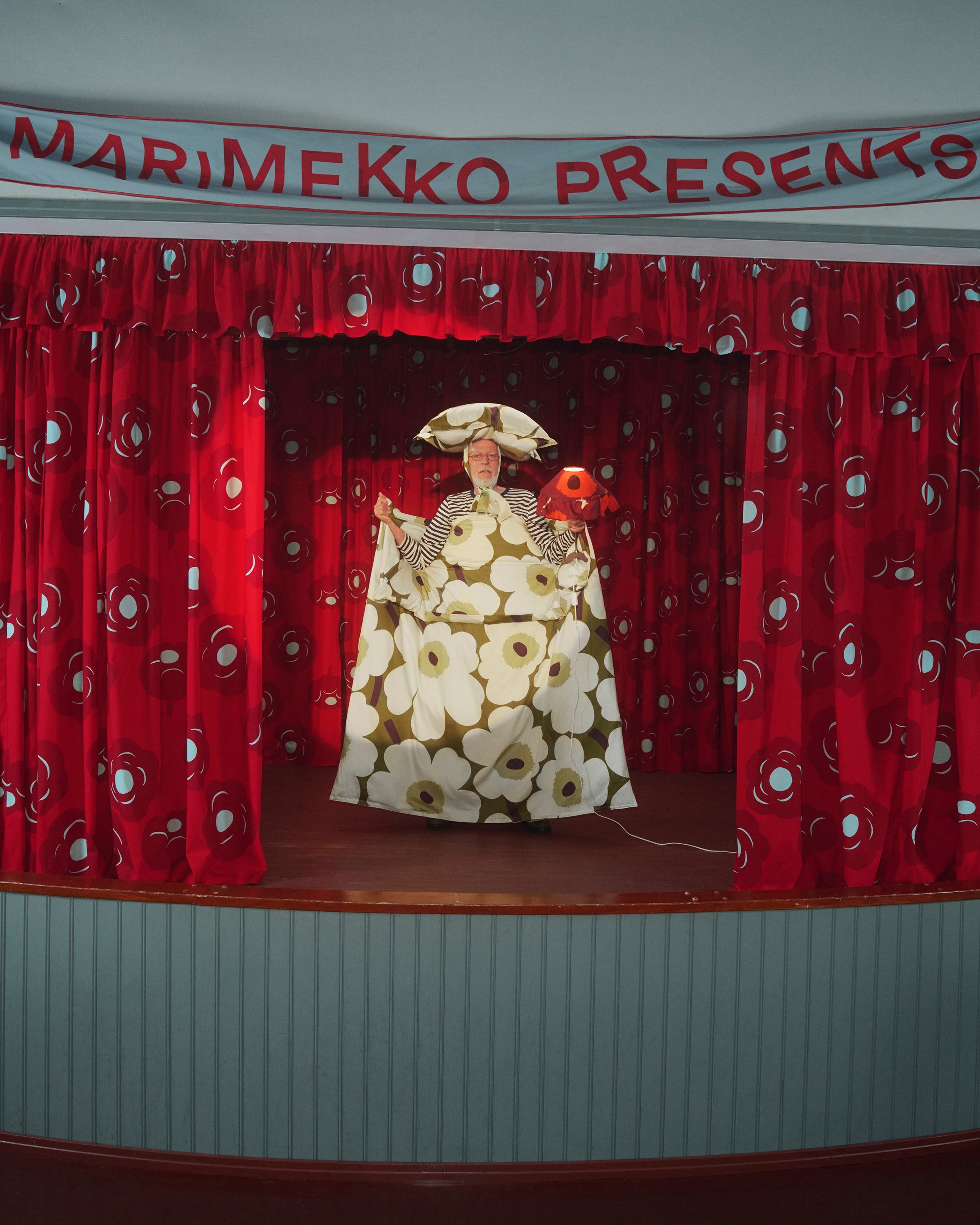 A model holding Unikko bedding on a stage.