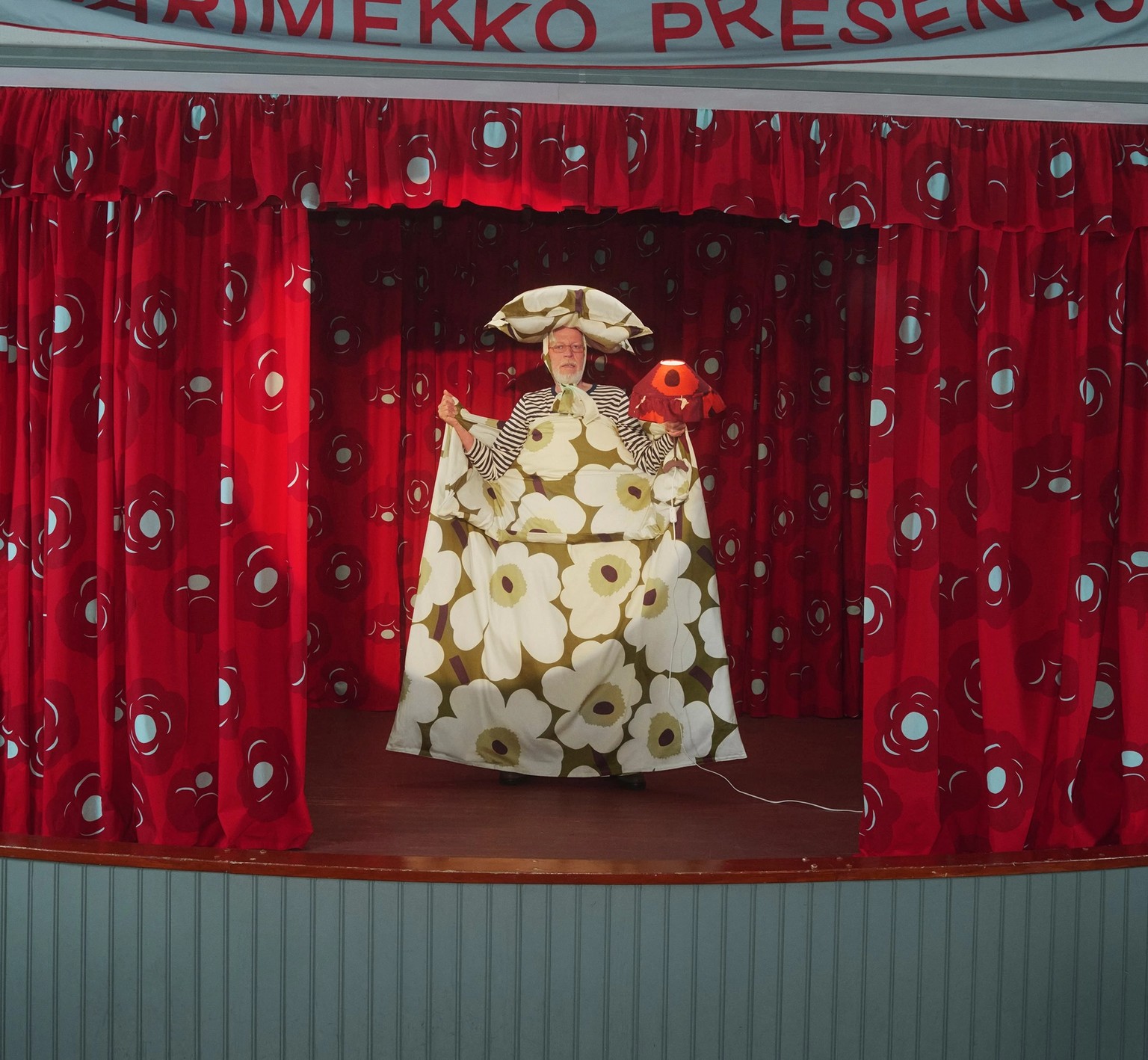 Malli pitämässä Unikko-pussilakanaa kädessään lavalla.