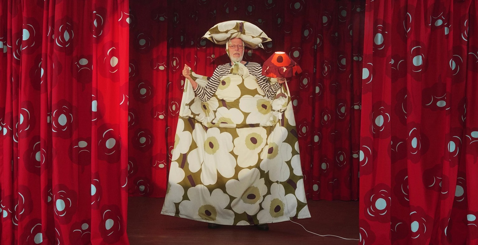 A model holding Unikko bedding on a stage.