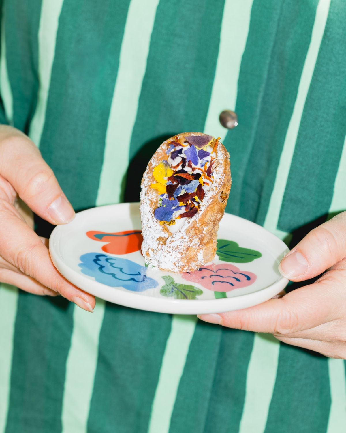 A person holding a dish with a dessert.