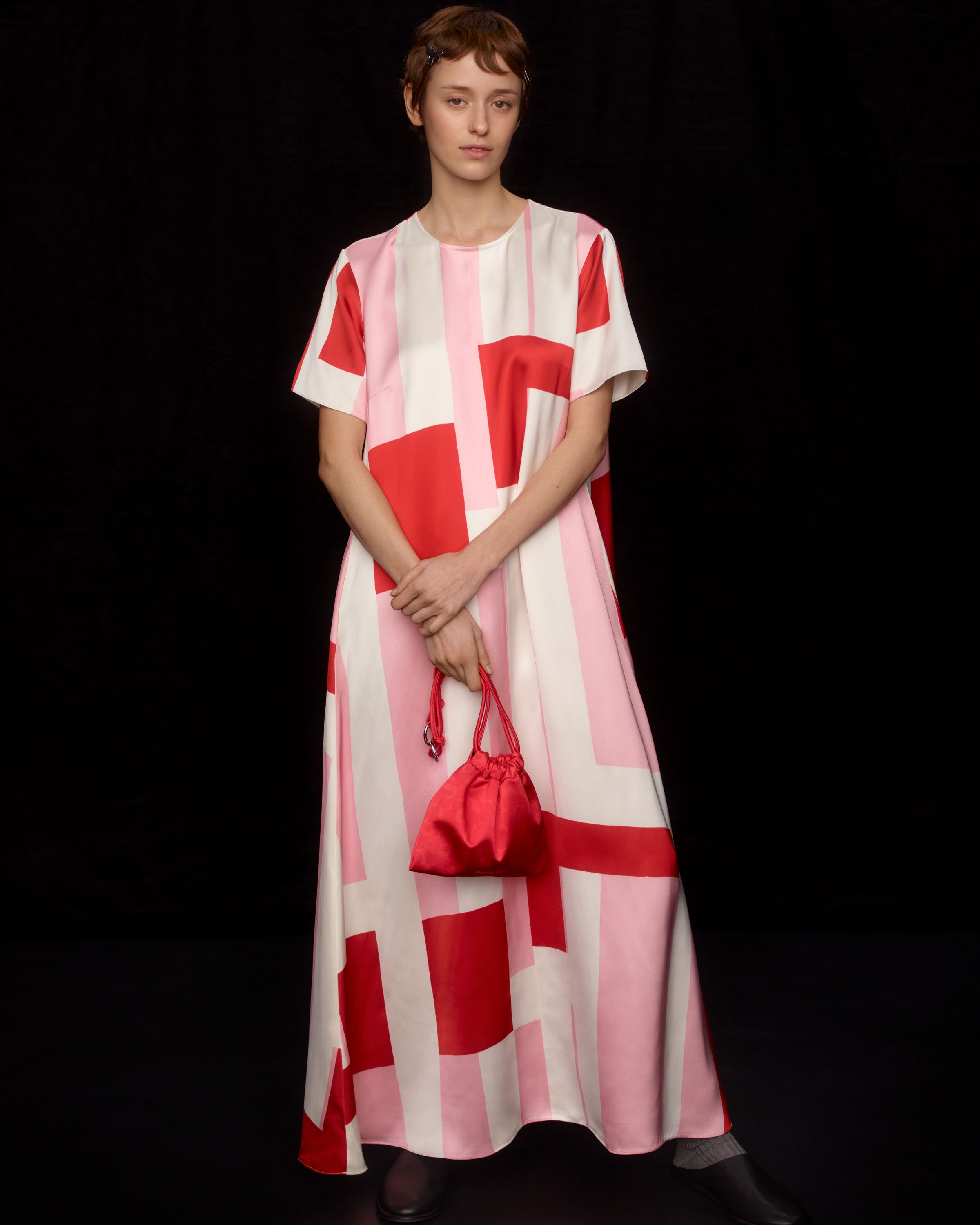 Model wearing a long t-shirt dress in red and pink Attika print.