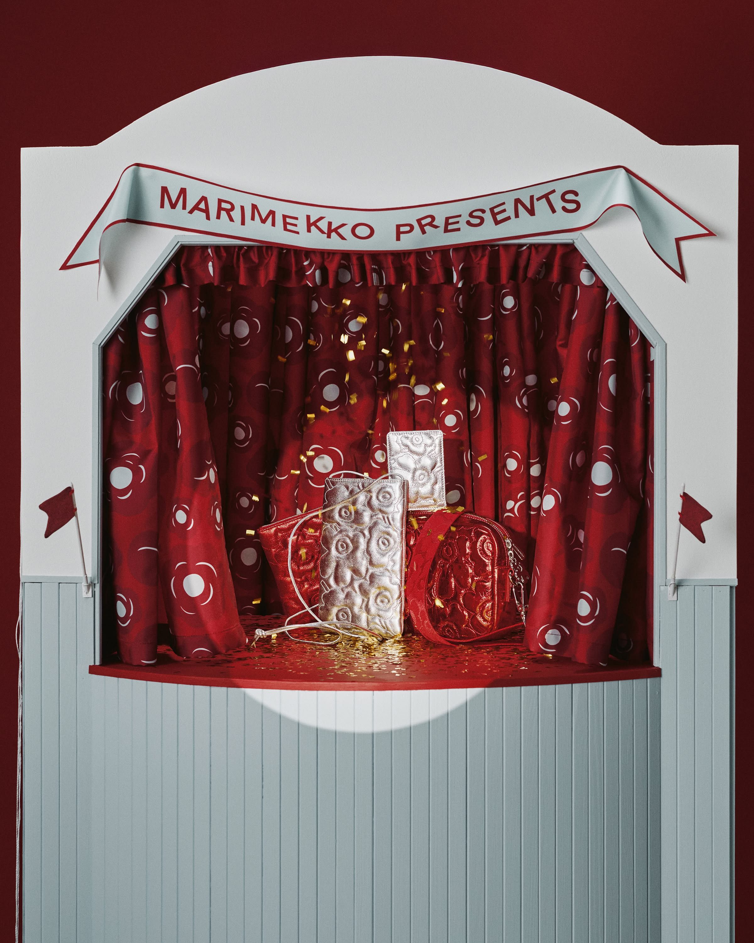 Kiiltäviä Unikko-kirjailtuja laukkuja asetelmassa.