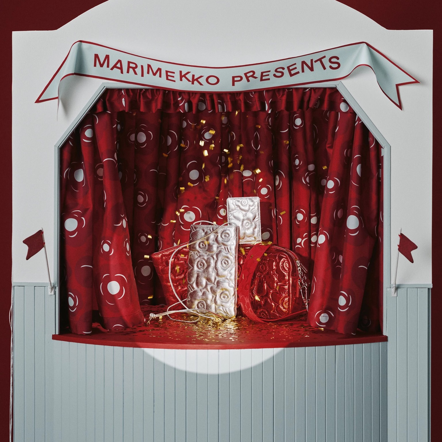 Kiiltäviä Unikko-kirjailtuja laukkuja asetelmassa.