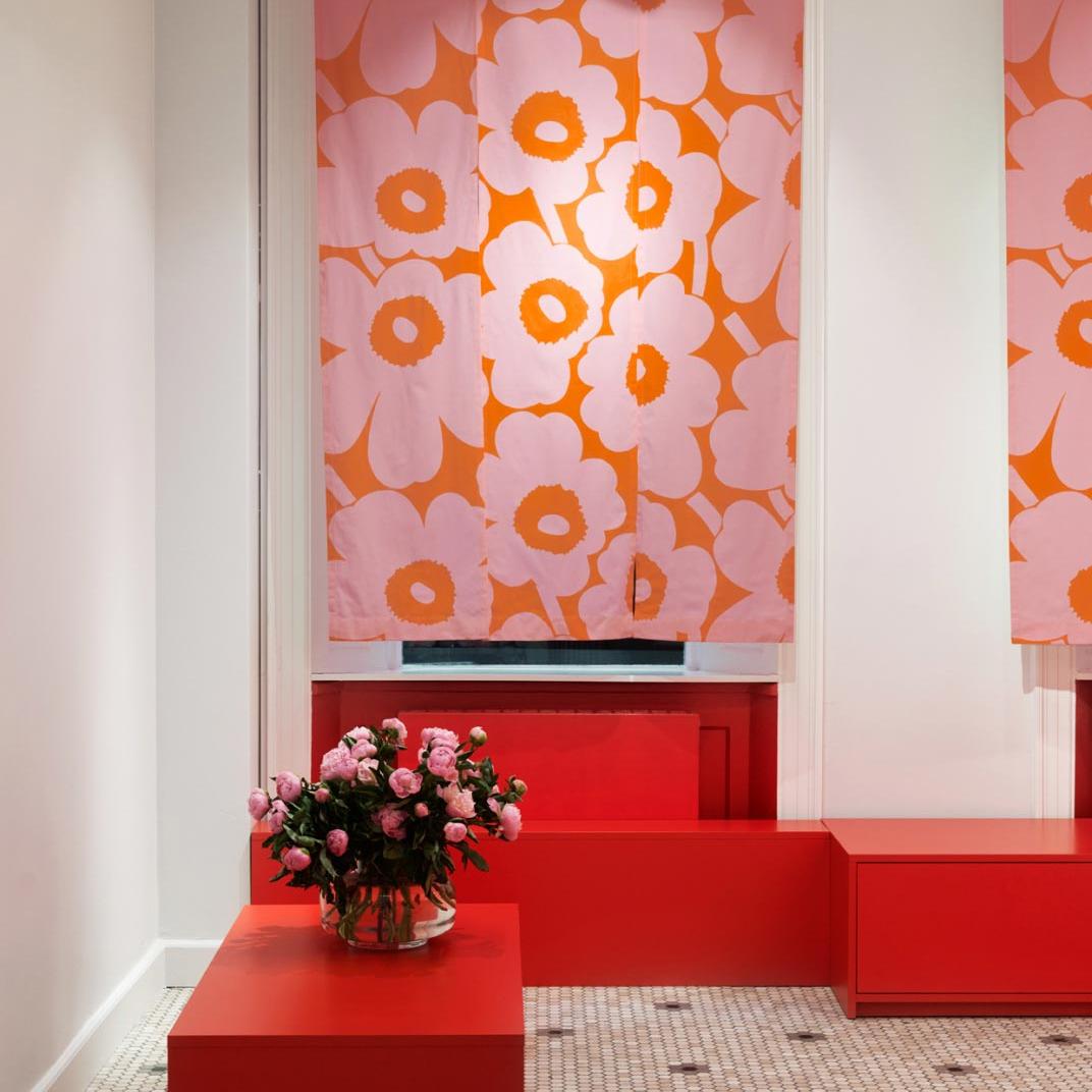 Piones in Urna vase and pink-orange curtains in Unikko pattern in Copenhagen store
