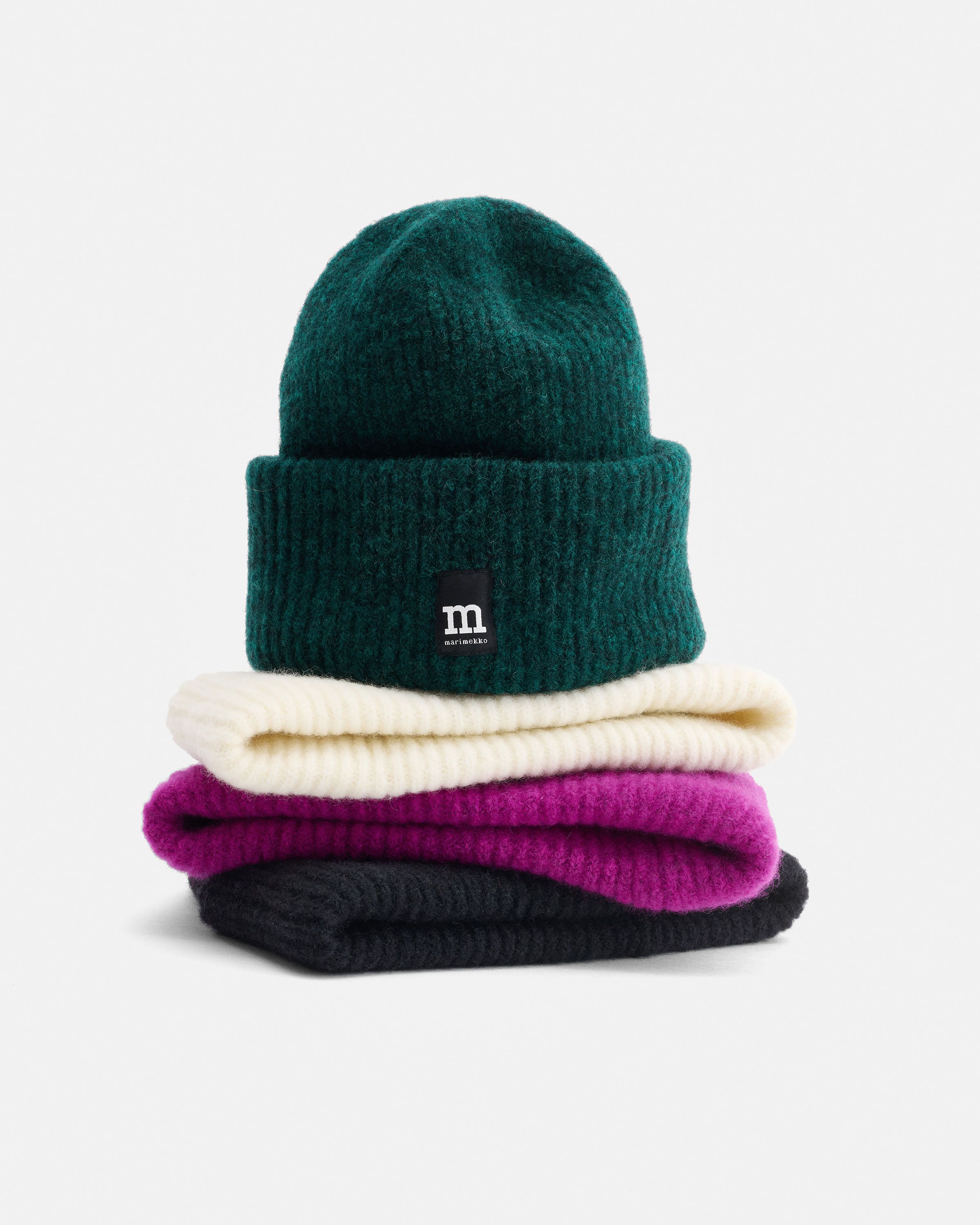 Värikkäitä pipoja pinossa.