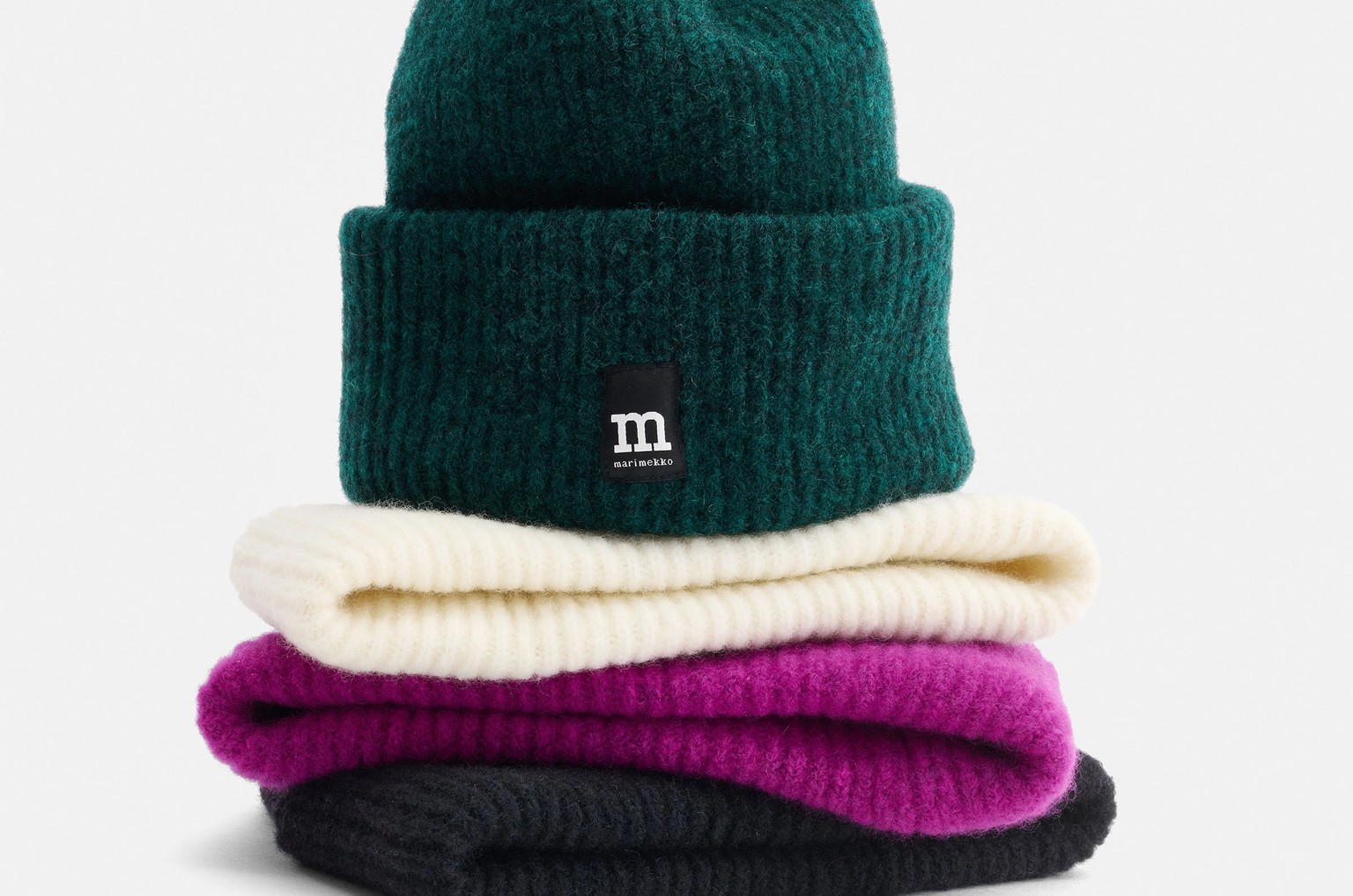 Värikkäitä pipoja pinossa.