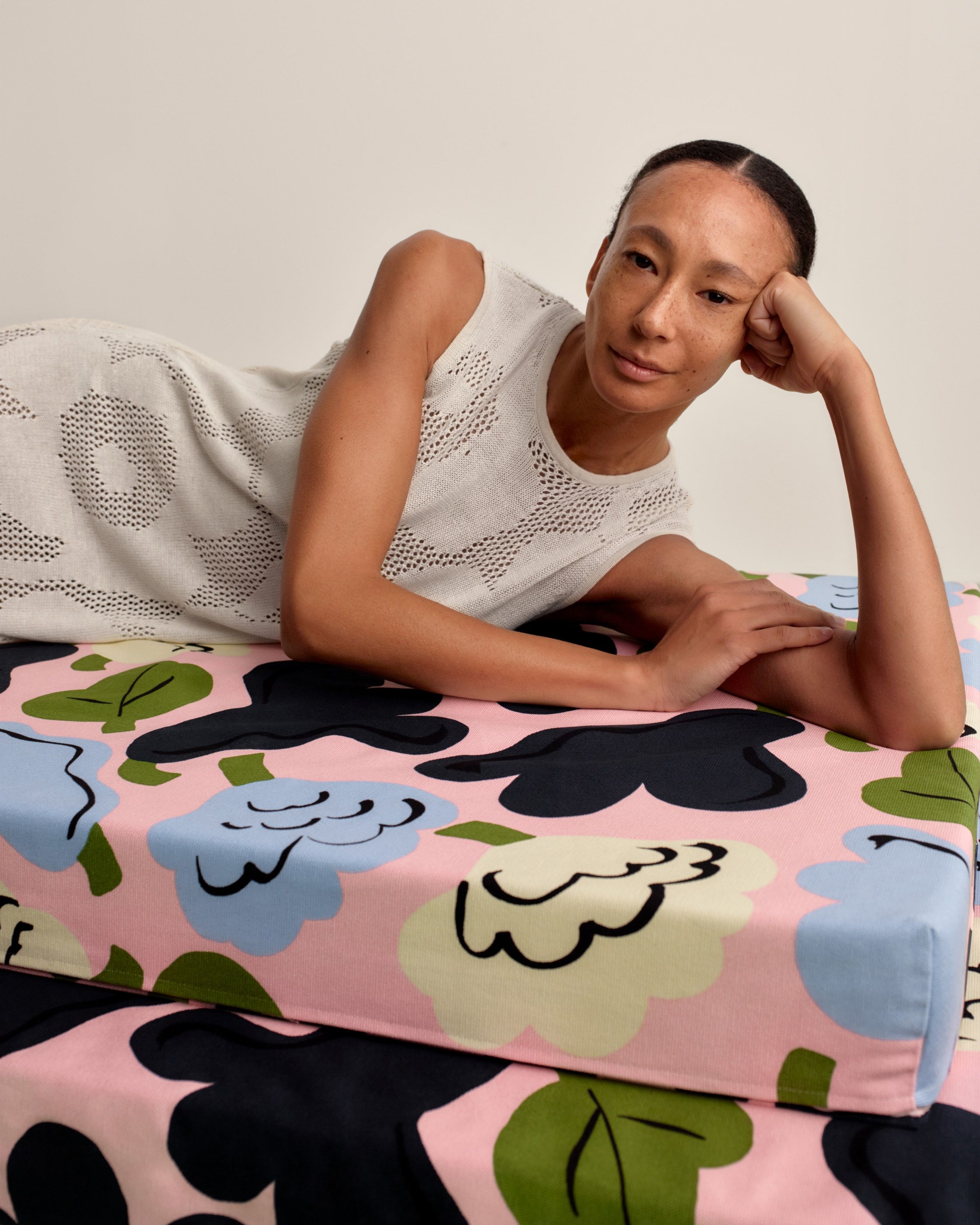 Model wearing a long and sleeveless white pointelle dress in Unikko print.