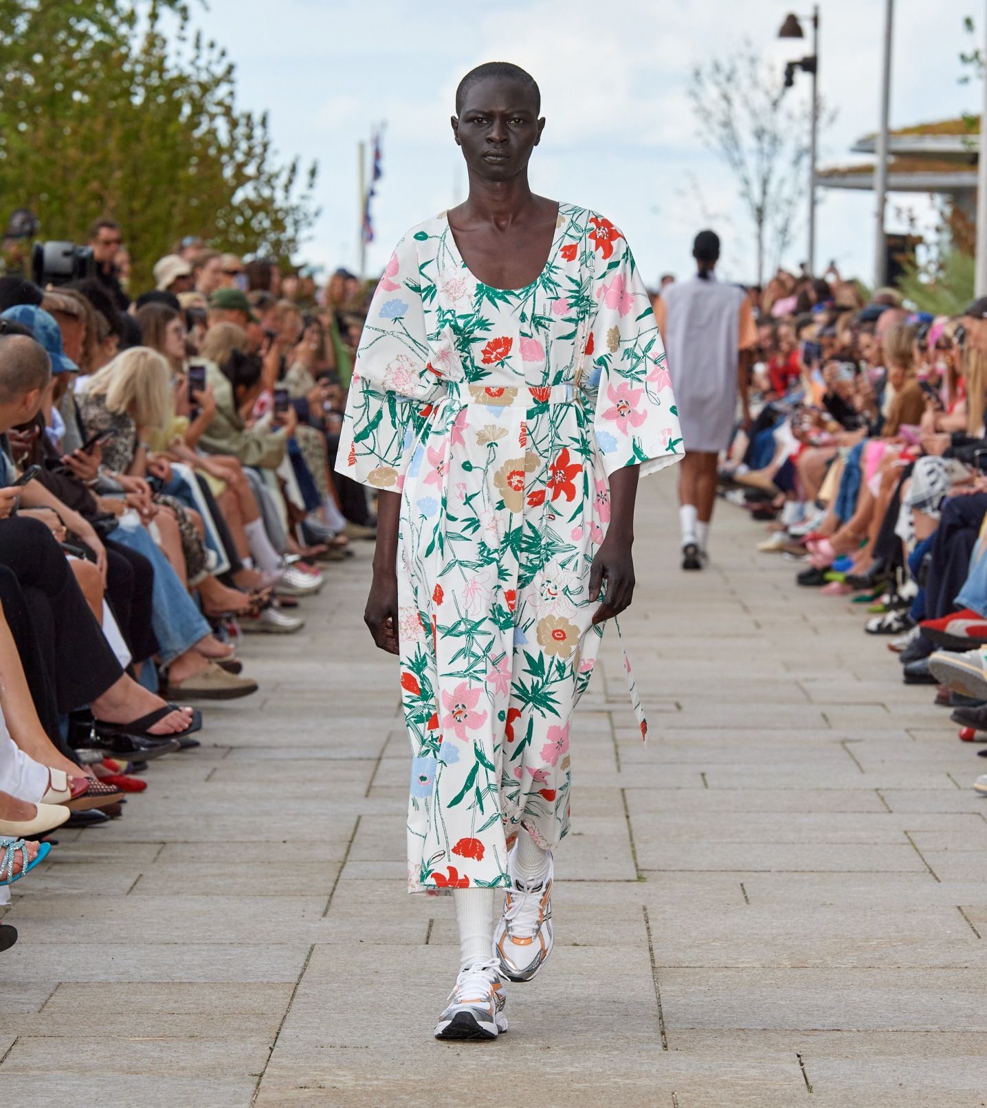 Model walking on the catwalk of the fashion show dressed in a Hymy Perenna dress.