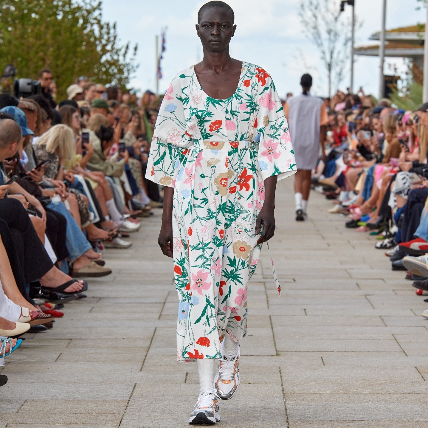 Model walking on the catwalk of the fashion show dressed in a Hymy Perenna dress.