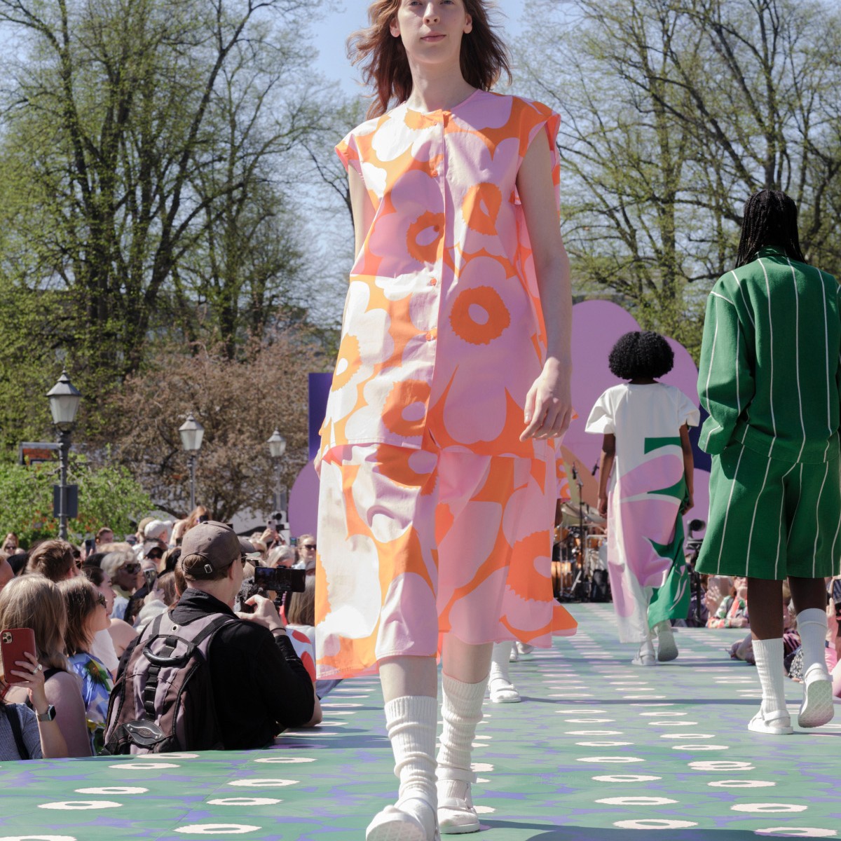 Model wearing pink and orange shirt and skirt in Unikko pattern.